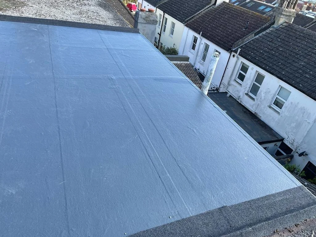 Blue liquid-applied waterproof finish on a residential flat roof