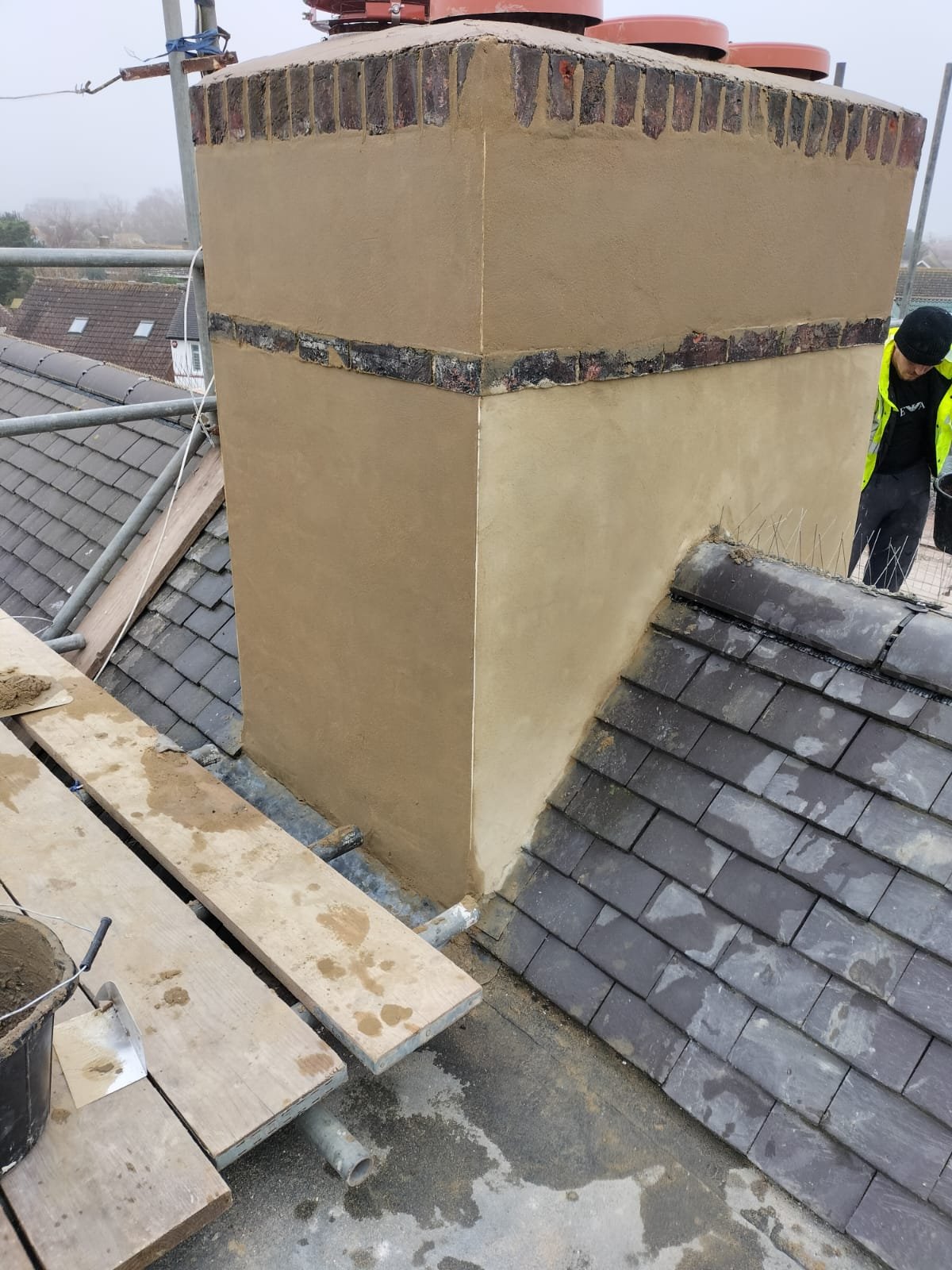Chimney render and tiled roof junction viewed from scaffold