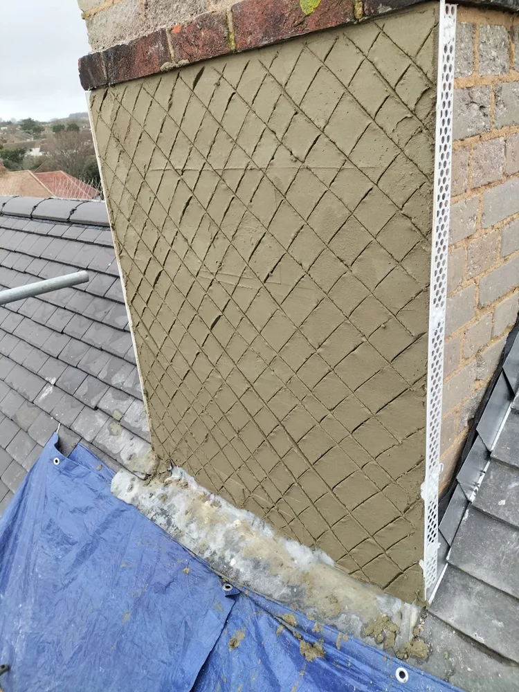 Prepared chimney stack receiving reinforced base coat before rendering