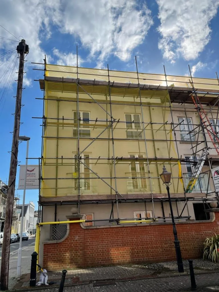 Sheeted scaffold protecting a house during external roofing work