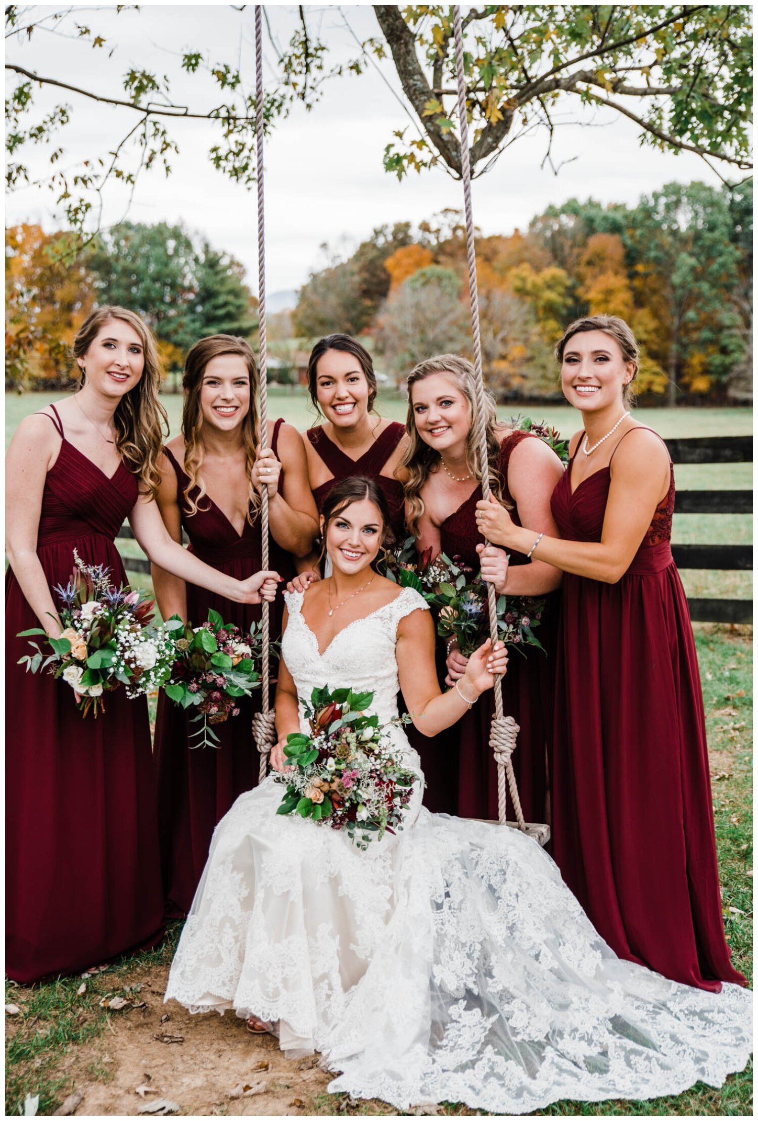 Red August Farm Wedding bride on swing with bridal party