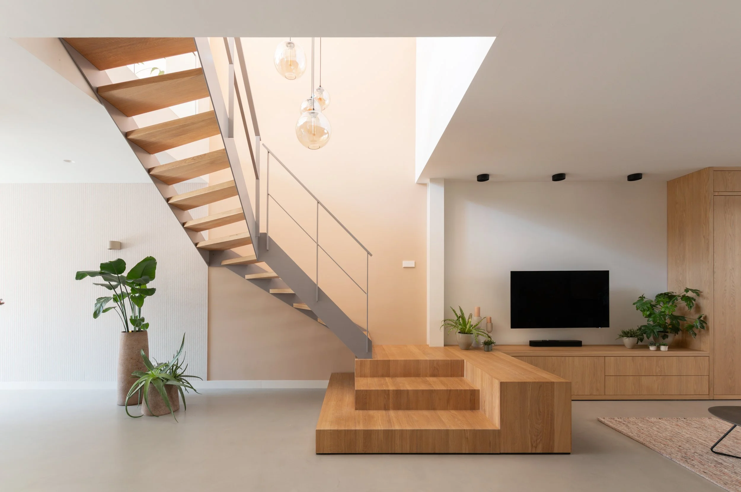 spectaculaire open houten trap. modern interieur met een wandmeubel van hout