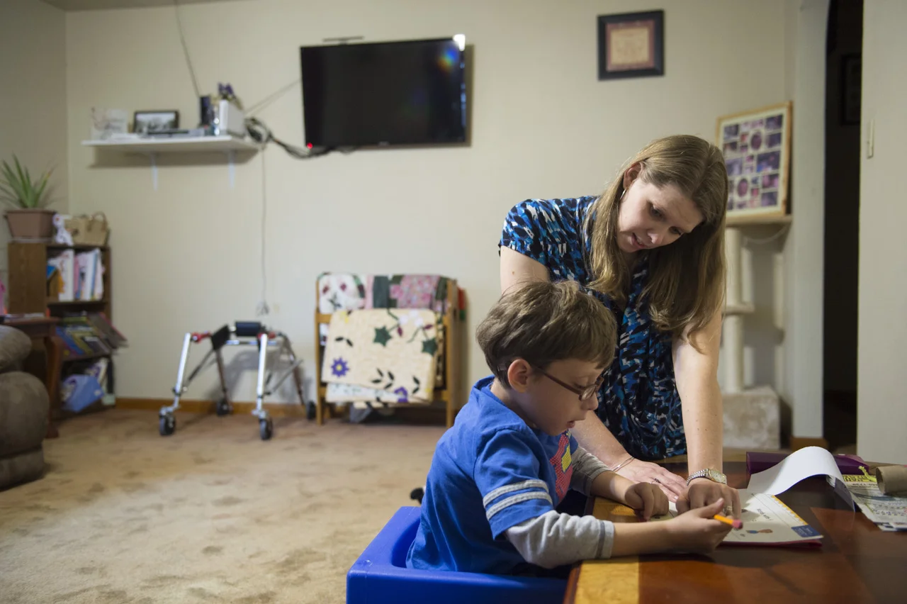  Crystal helps Josiah with his homework in their living room in Charleston, W.Va. 
