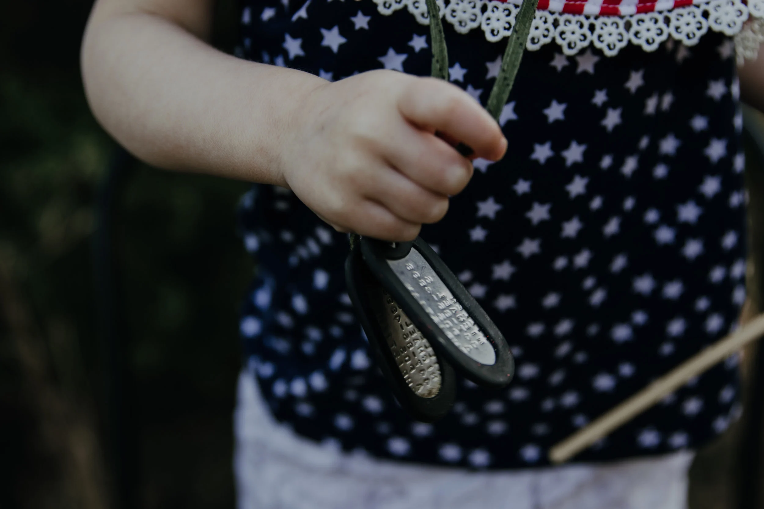 Holding her papa's dog tags