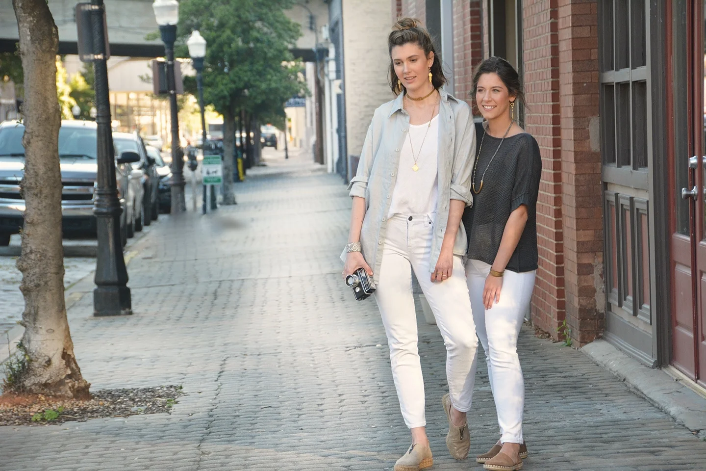 A stroll with a friend. MODEL ON LEFT: Linen Boyfriend Shirt in Dove Gray $92 , 17" Choker Necklace $79 , Moonstone Necklace with Phelps Slide Pendant $289 , Amy Earrings with Moonstone $79 , Python Cuff $98 MODEL ON RIGHT: Cotton Short Sleeve Sweater in Ink $82 , Half Moon Labradorite Necklace $189 , Half Moon Labradorite Earrings $69 , Tallulah $79