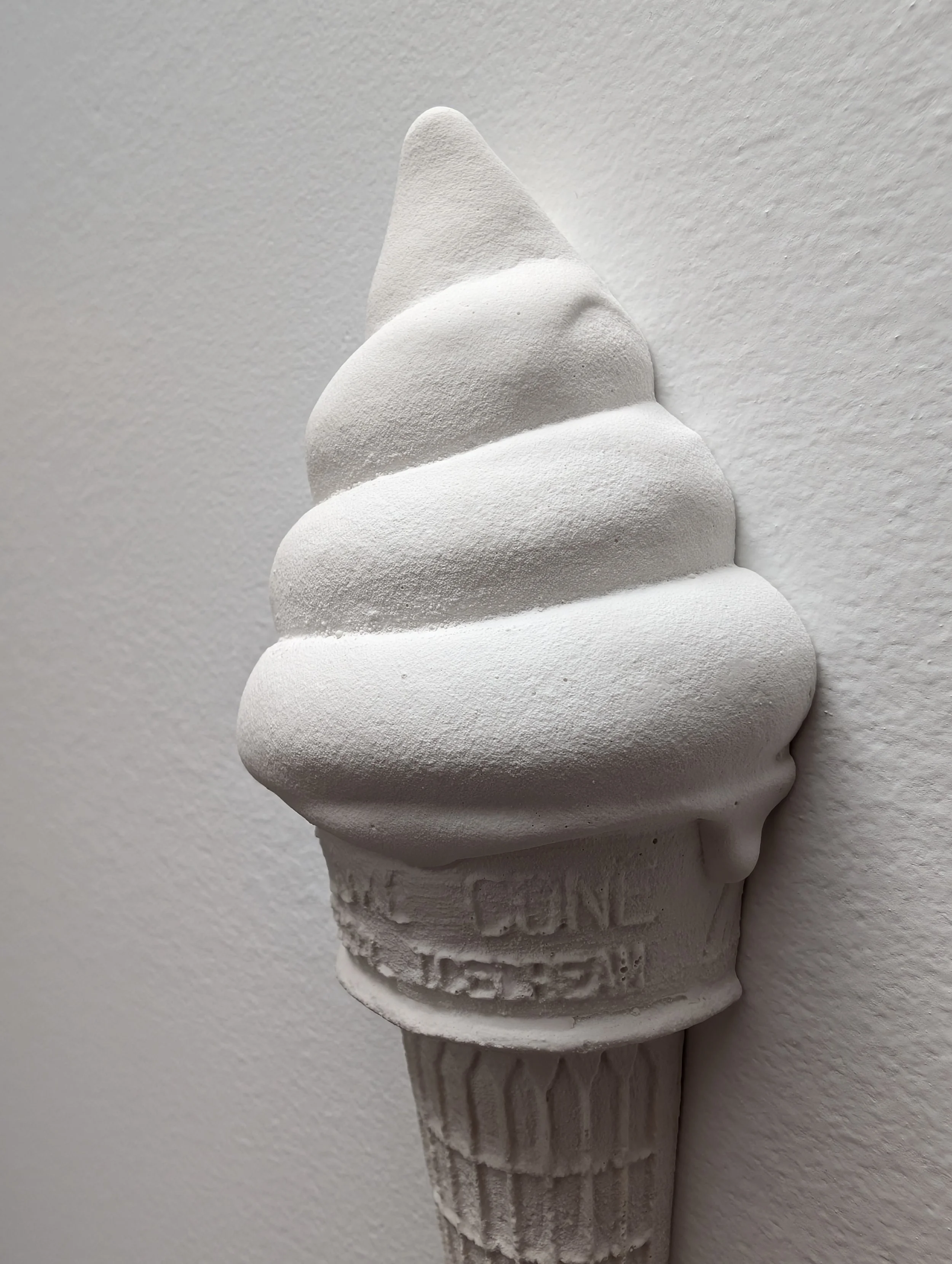 Sculptural ridges and textures of a wall-mounted ice cream artwork.