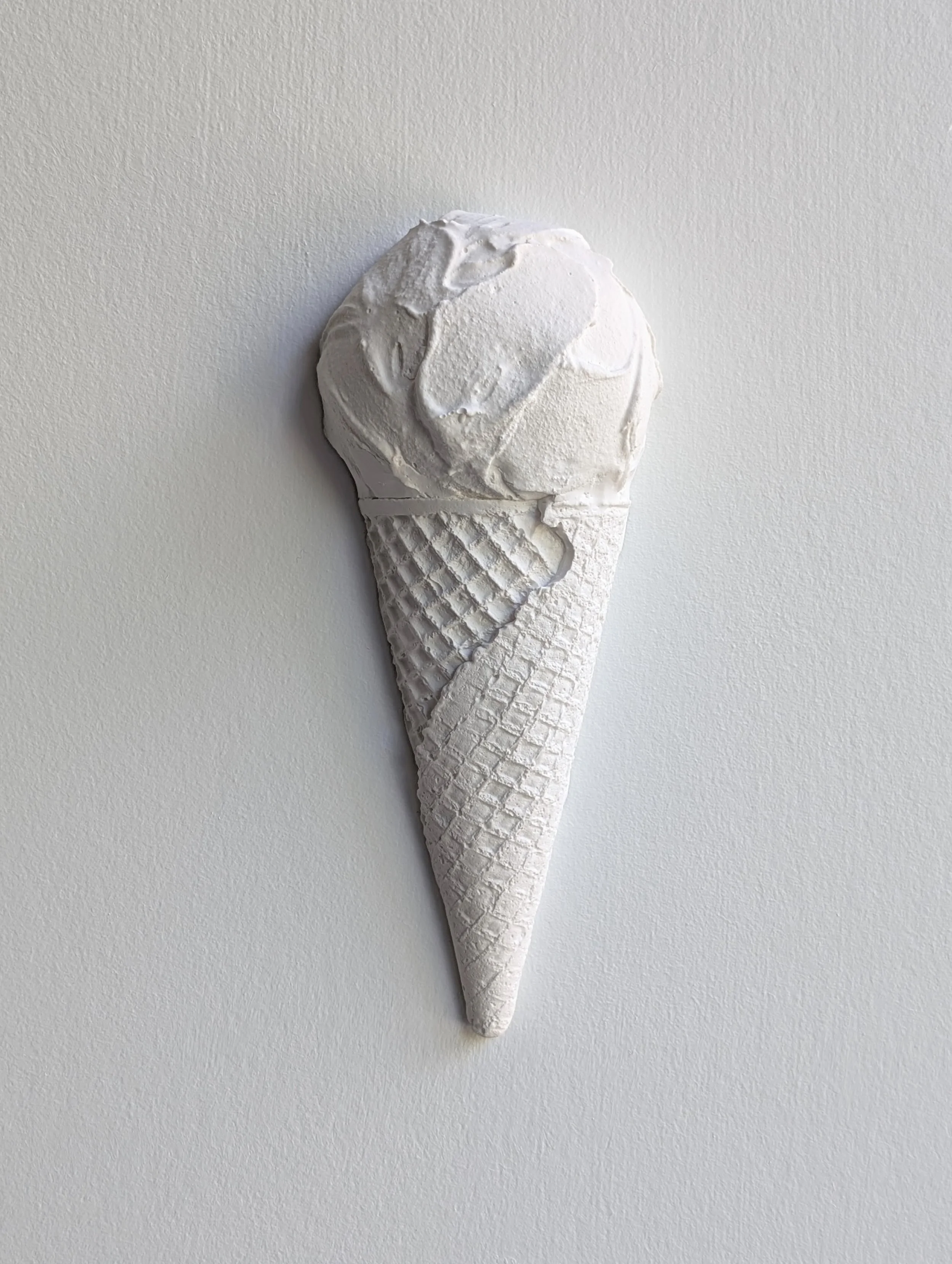 White sculptural wall artwork of a gelato ice cream with a waffle cone. Created from hydrocal plaster in Vancouver, Canada by Lindsay Cohen
