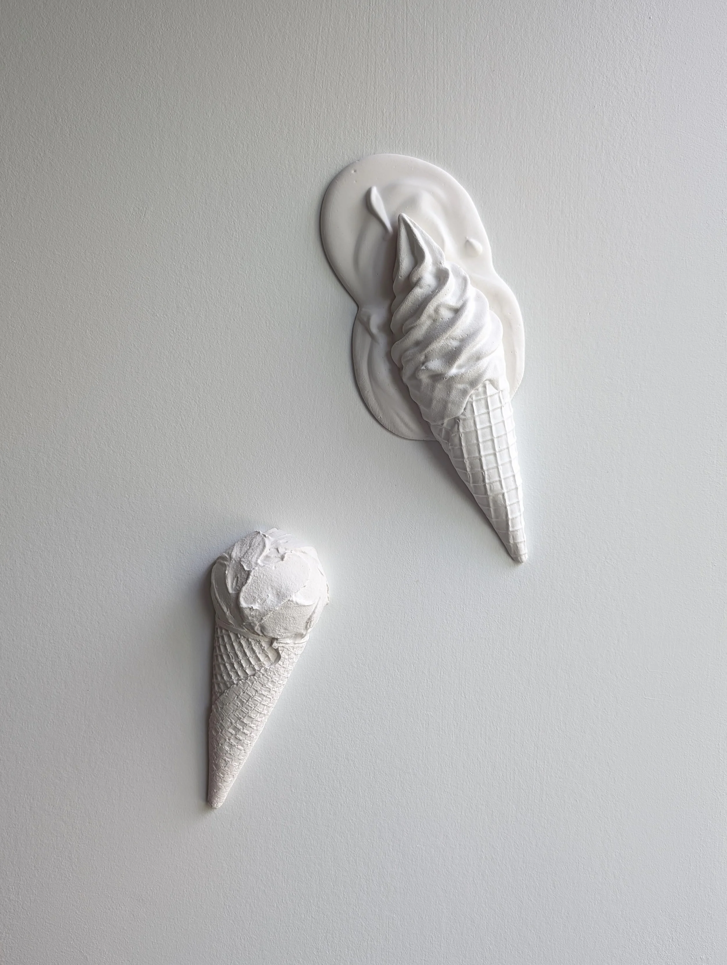 Wall mounted ice cream artwork by artist Lindsay Cohen, featuring two minimalist plaster wall sculptures of ice creams.
