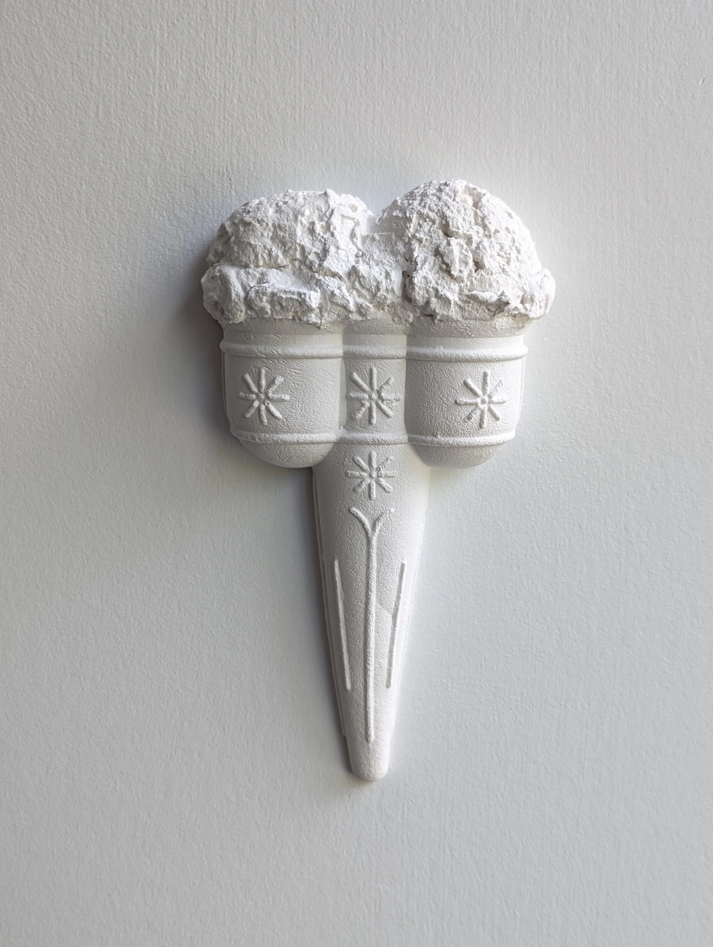 Photo of an all-white wall-mounted ice cream artwork, featuring a vintage double cone and scoops. Sculpture created by Lindsay Cohen in Vancouver, Canada.
