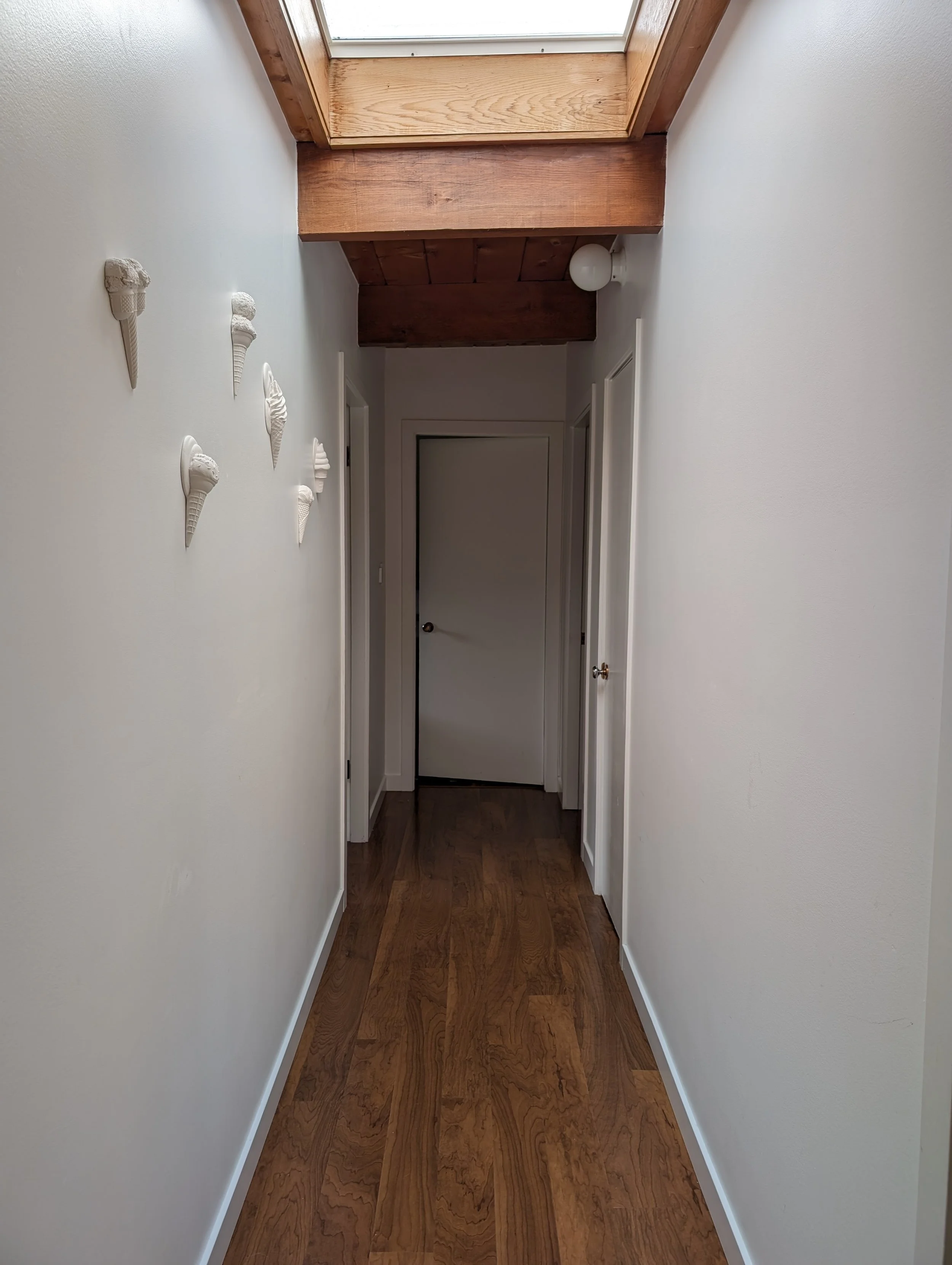 Handmade wall-mounted plaster ice cream sculptures in a warm minimalist home in Vancouver, Canada.