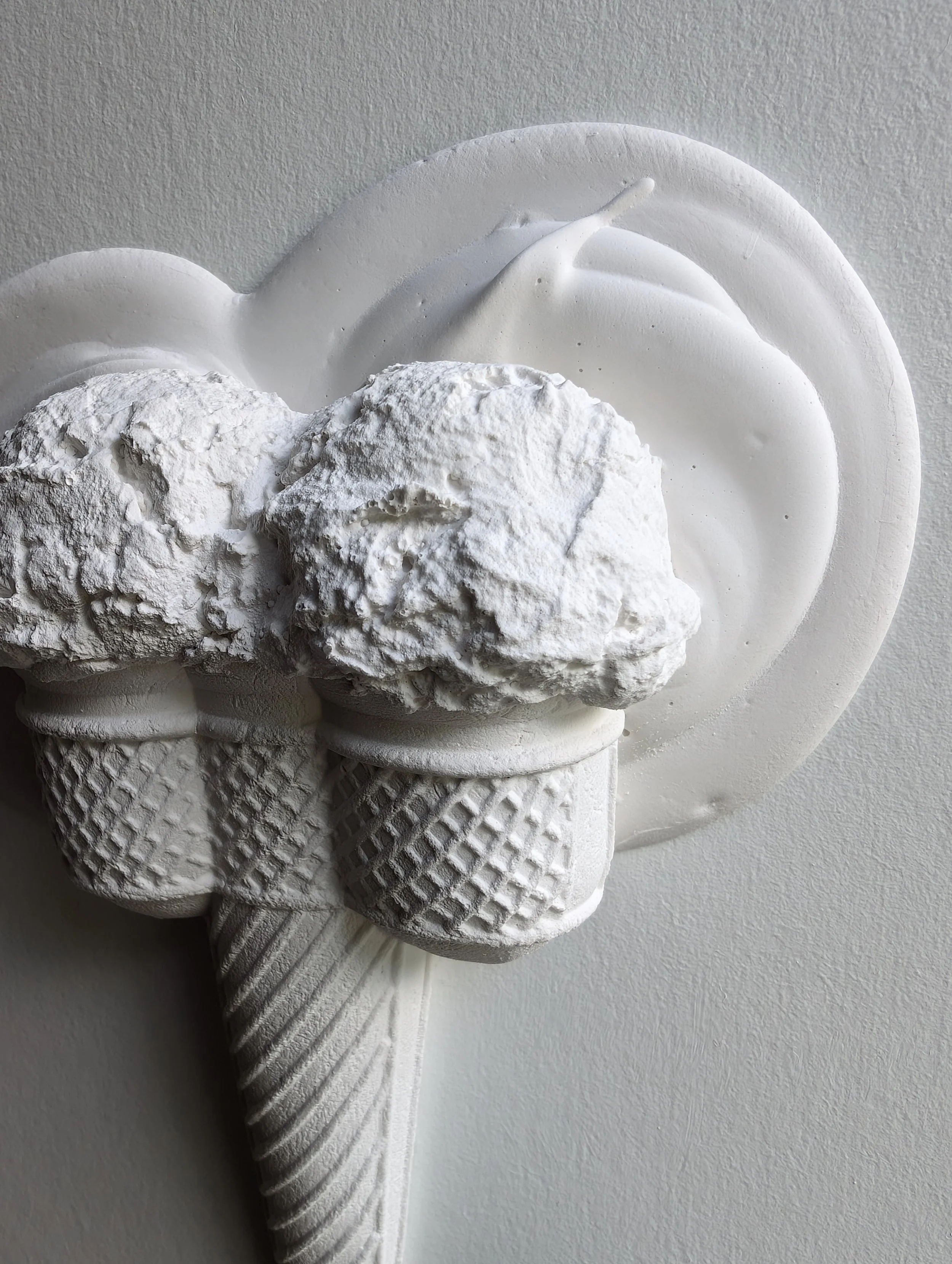 Detailed sculptural view of wall-mounted ice cream artwork, showing rich textures and matte white minimalist finish.