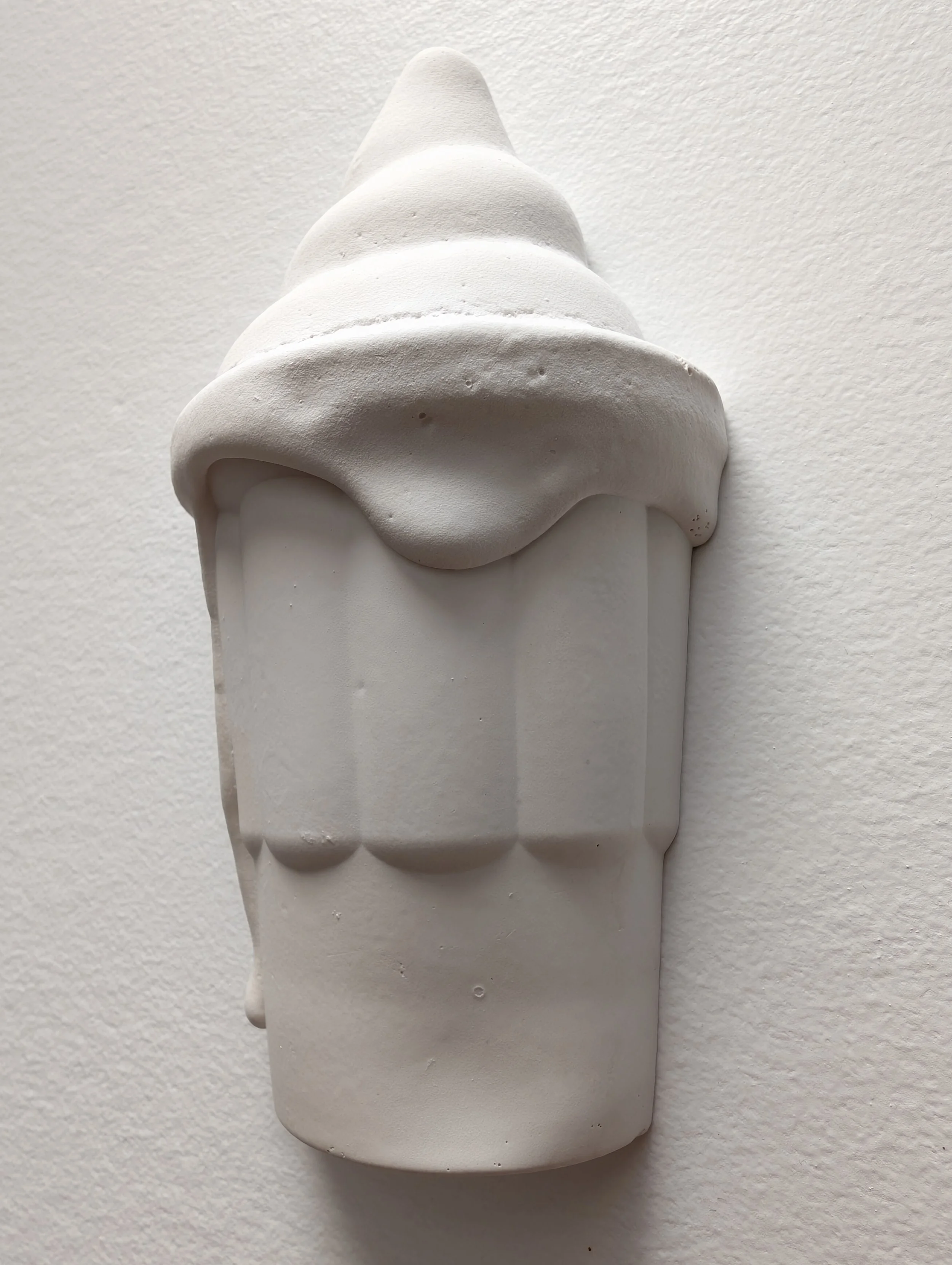 Wall-mounted all-white hydrocal sculpture of a dripping, melting ice cream.