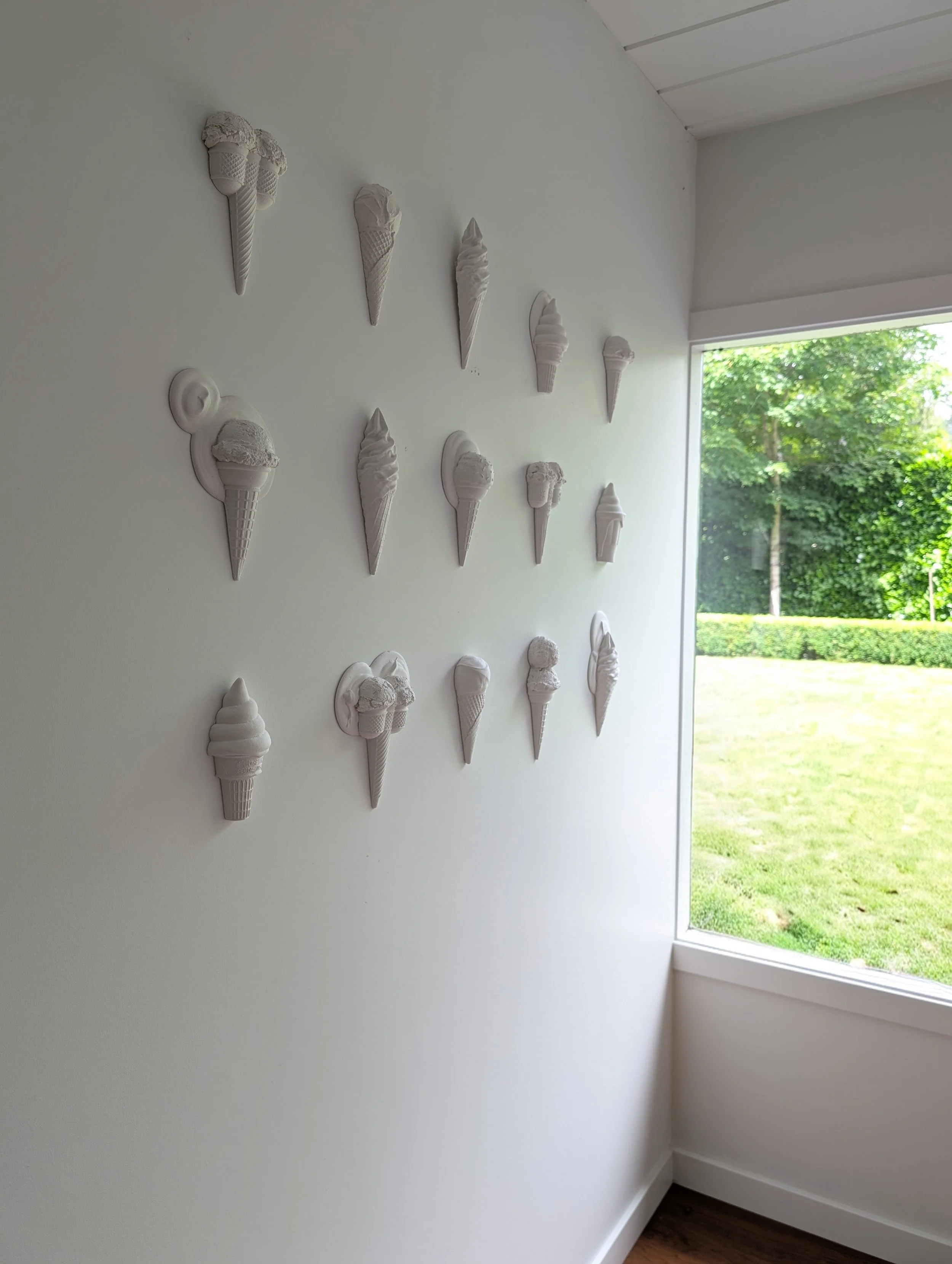 Installation view of white minimalist gallery wall sculptures by artist Lindsay Cohen, in Vancouver, Canada.