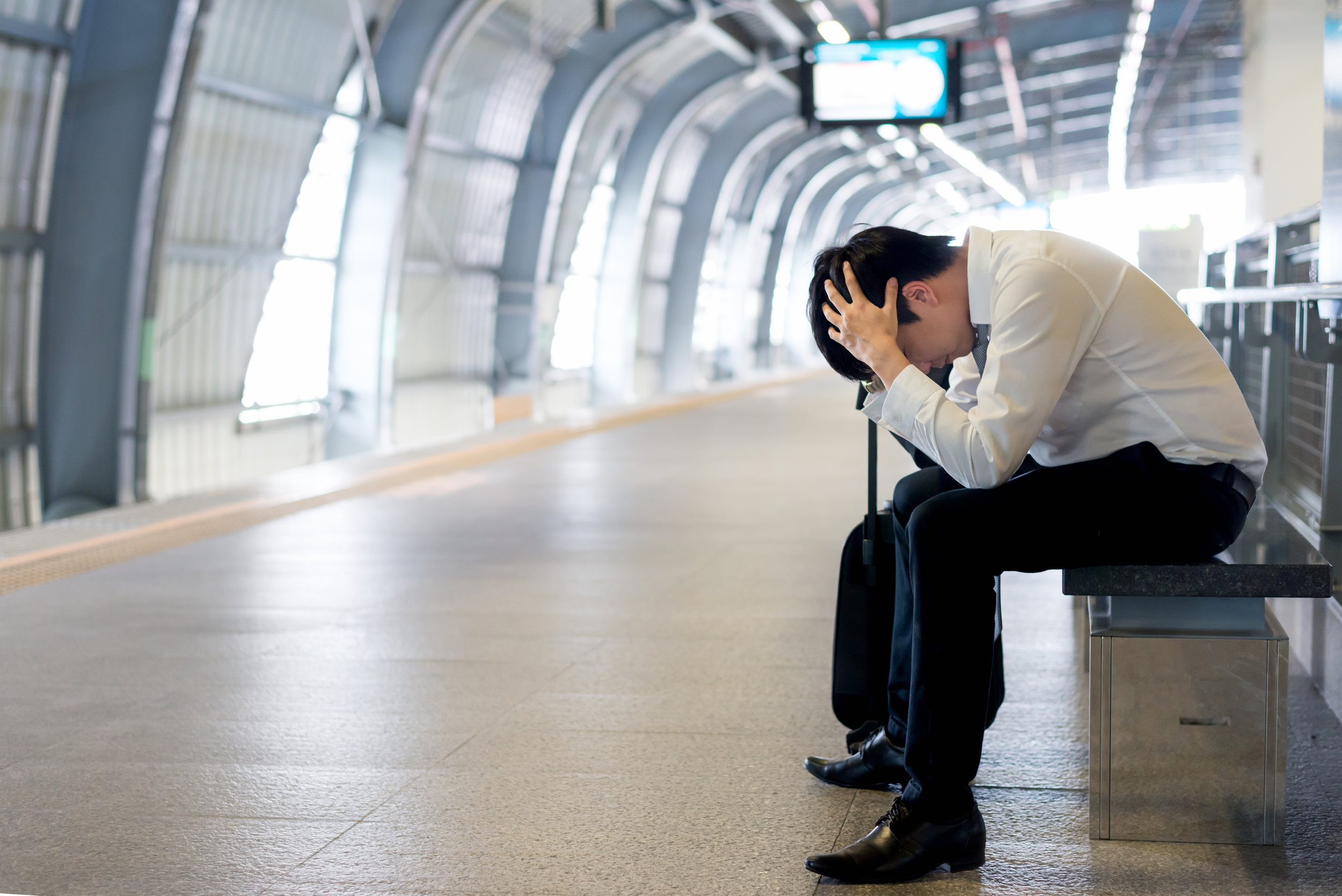 Train-delay-or-problem-in-the-train-station,-tired-desperate-Asian-passenger-waiting-in-the-terminal-with-suitcase.-860695940_3866x2580 (1).jpeg
