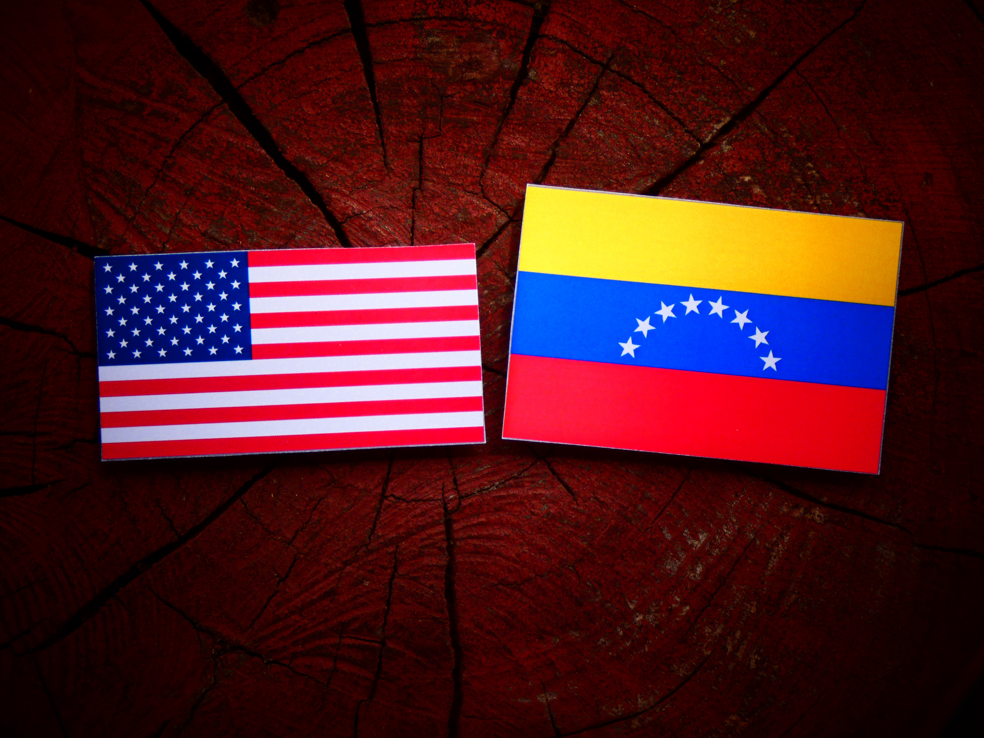 USA-flag-with-Venezuelan-flag-on-a-tree-stump-isolated-823303598_2003x1502.jpeg