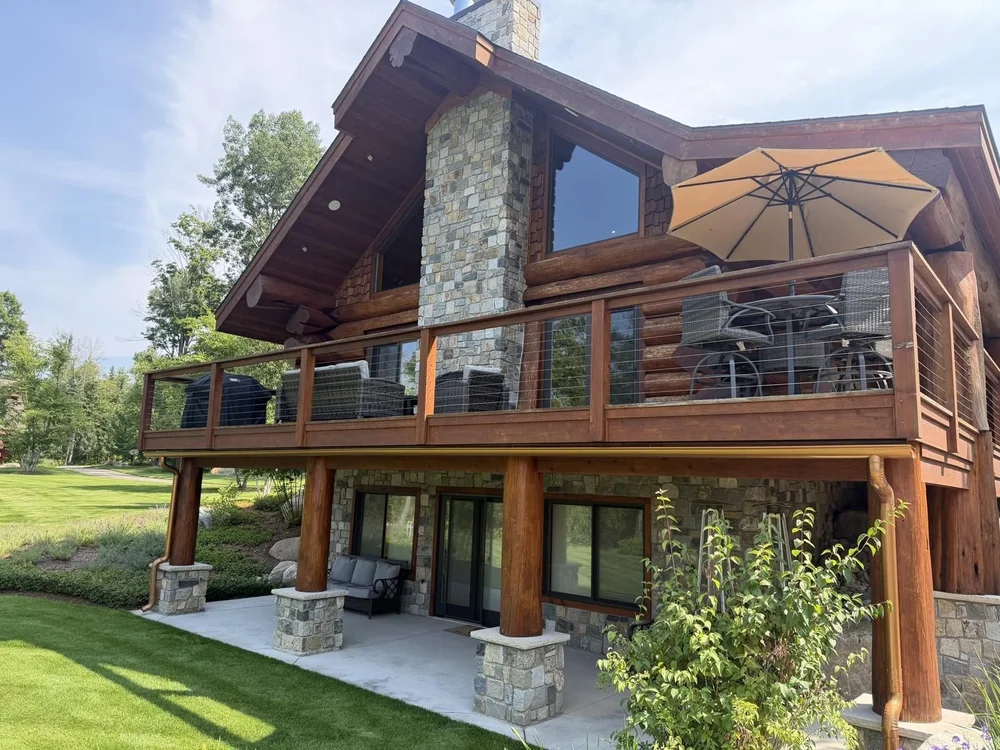 Log chalet with a wraparound deck and covered patio