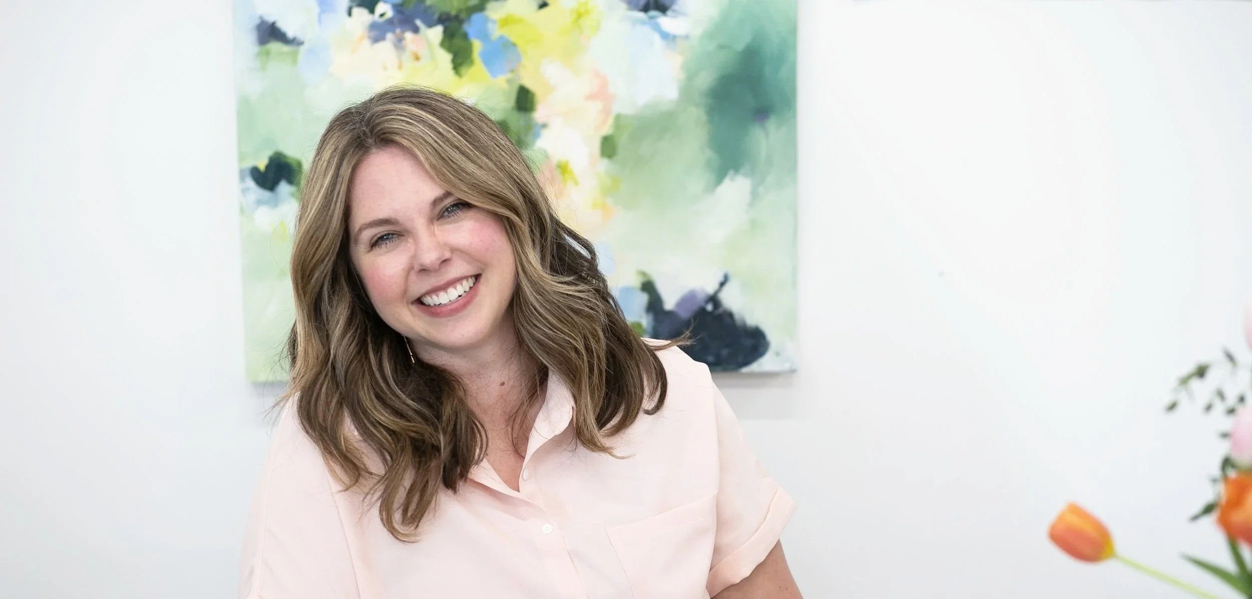 Nicole Bissett, Christian coach and writer smiling indoors in front of abstract art