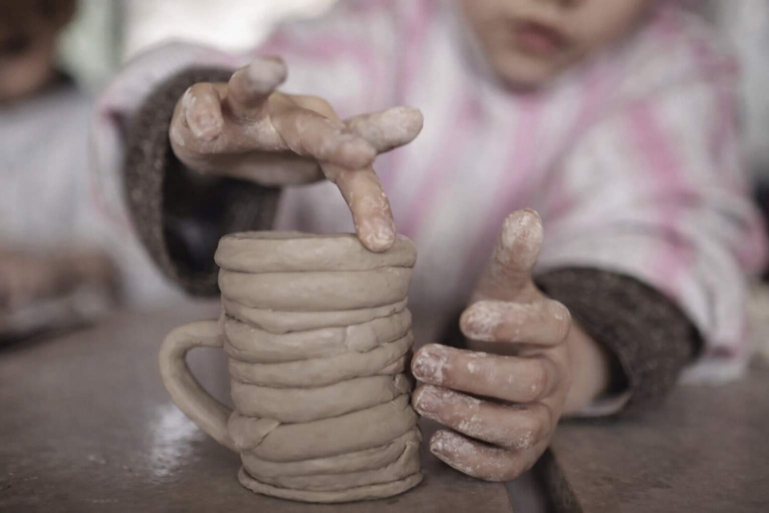 Shaping the clay mug by hand.png