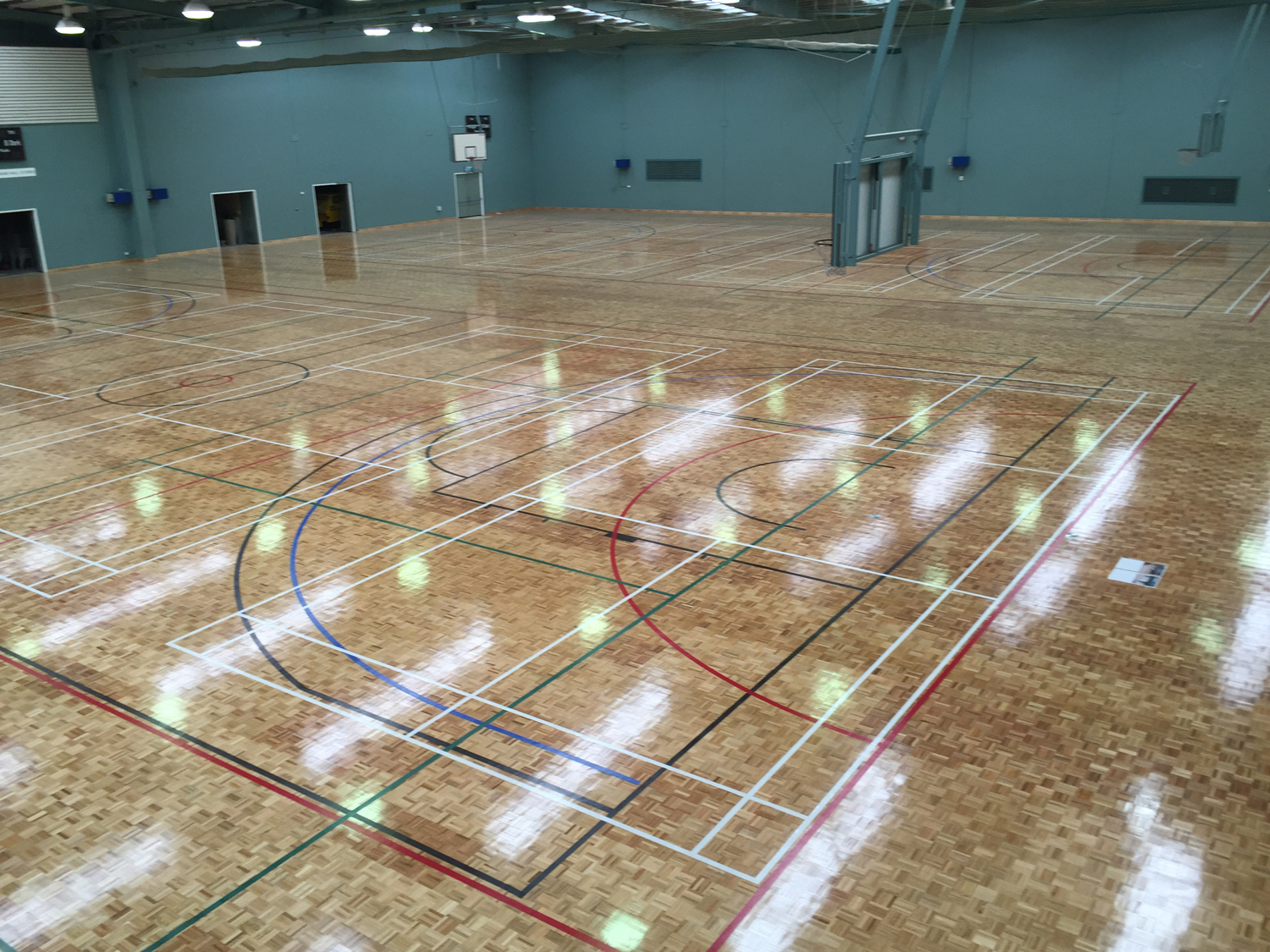 Polished sprung timber floor for indoor basketball court Perth
