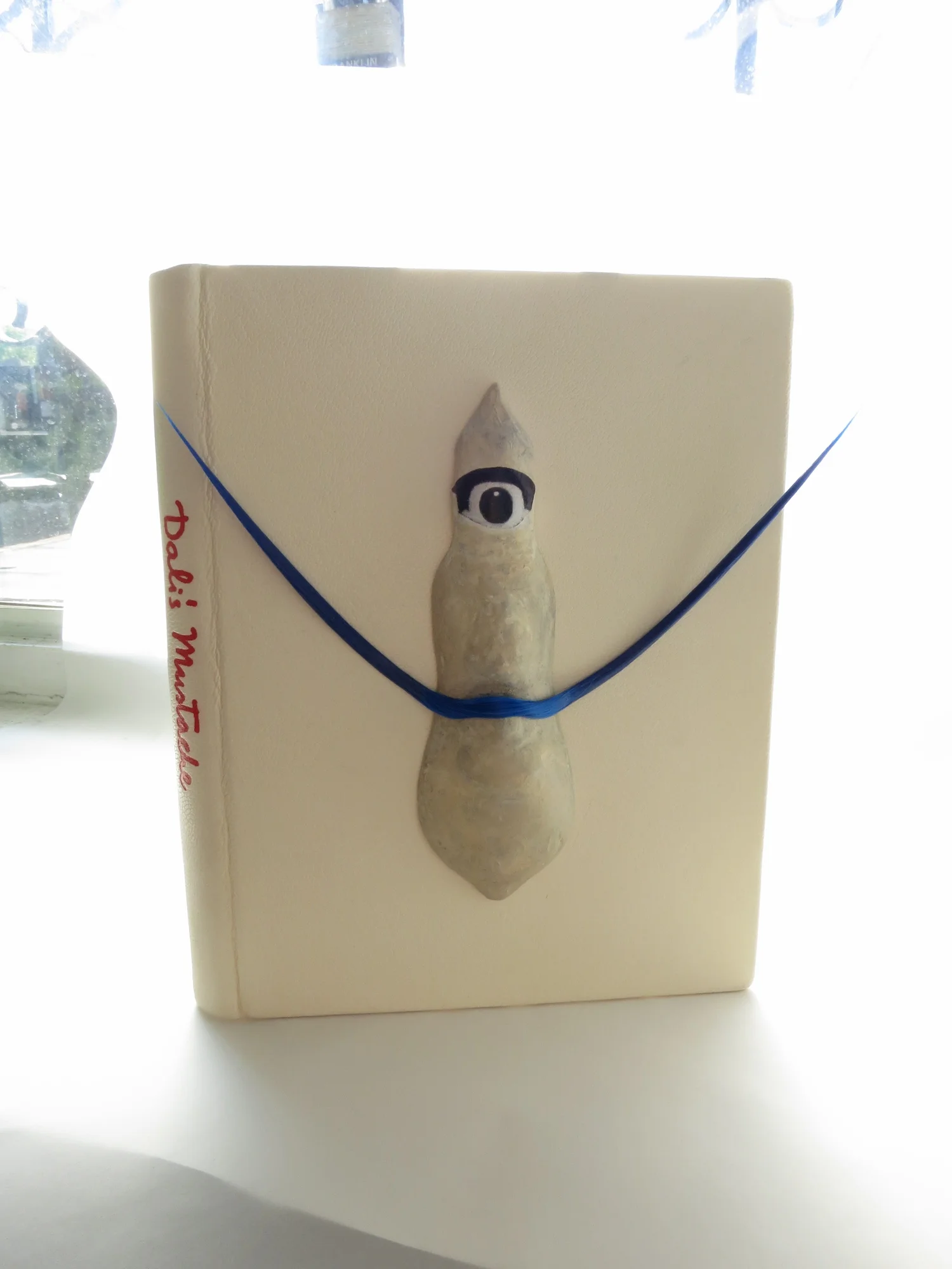 "DALI'S  MUSTACHE"   (19cm x 13cm; alum tawed goat skin, papier-mâchè, hot stamping)