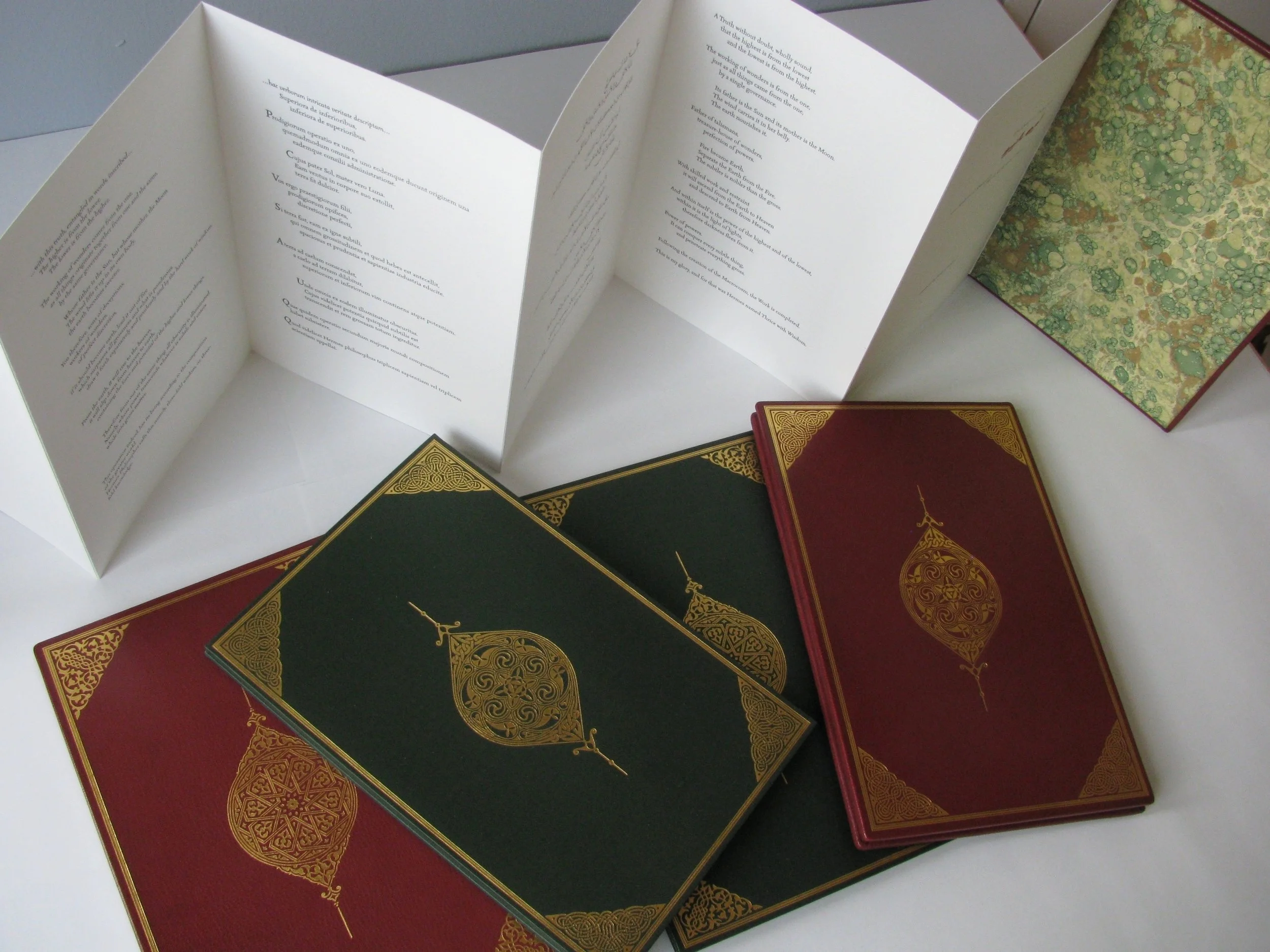 the EMERALD TABLET (h:9 5/8" x w:6 3/8"; green silk, burgundy leather, 23k gold)