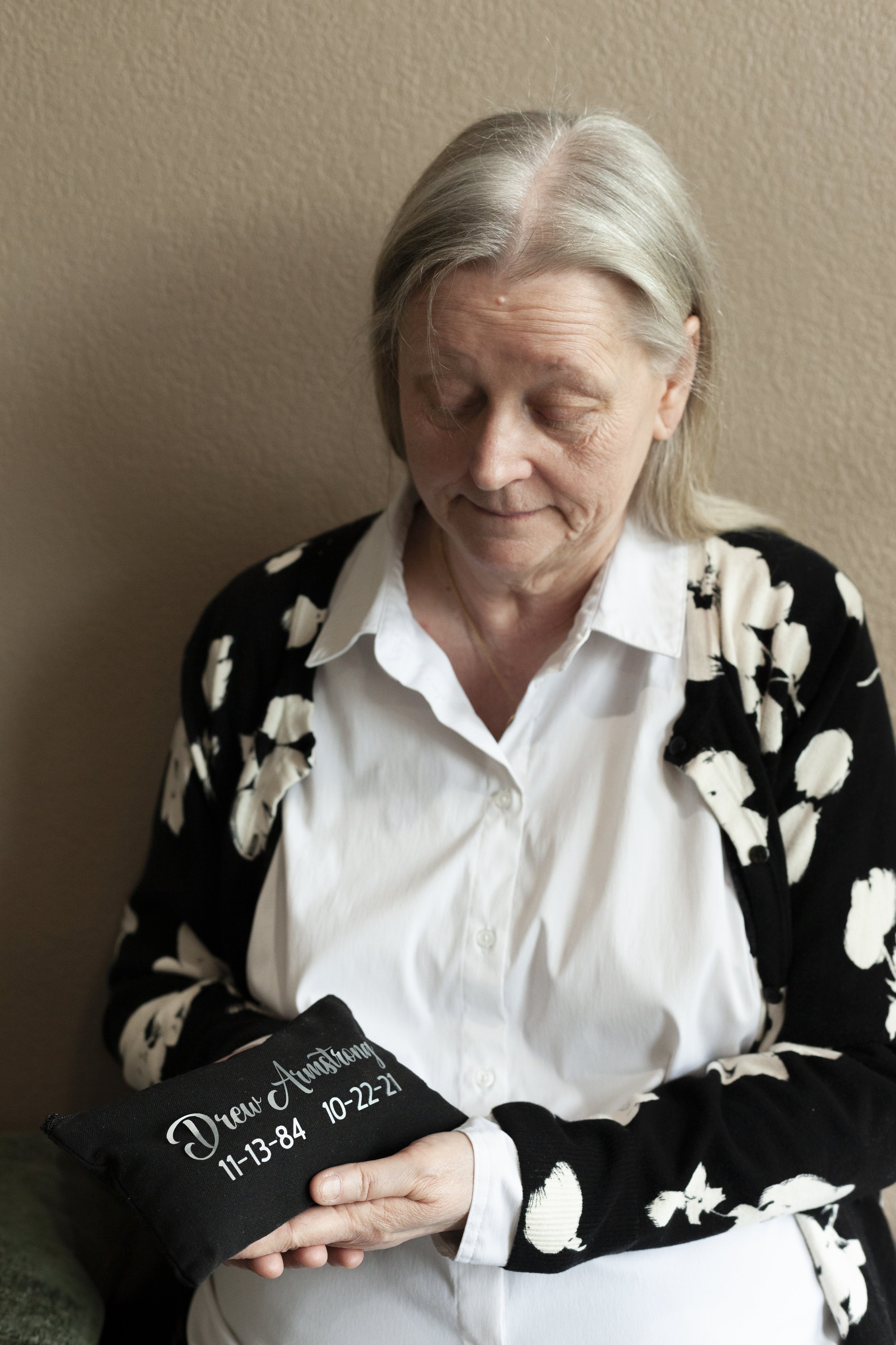 Cindy Armstrong holds a bag of her son's soil at Return Home for L'Obs