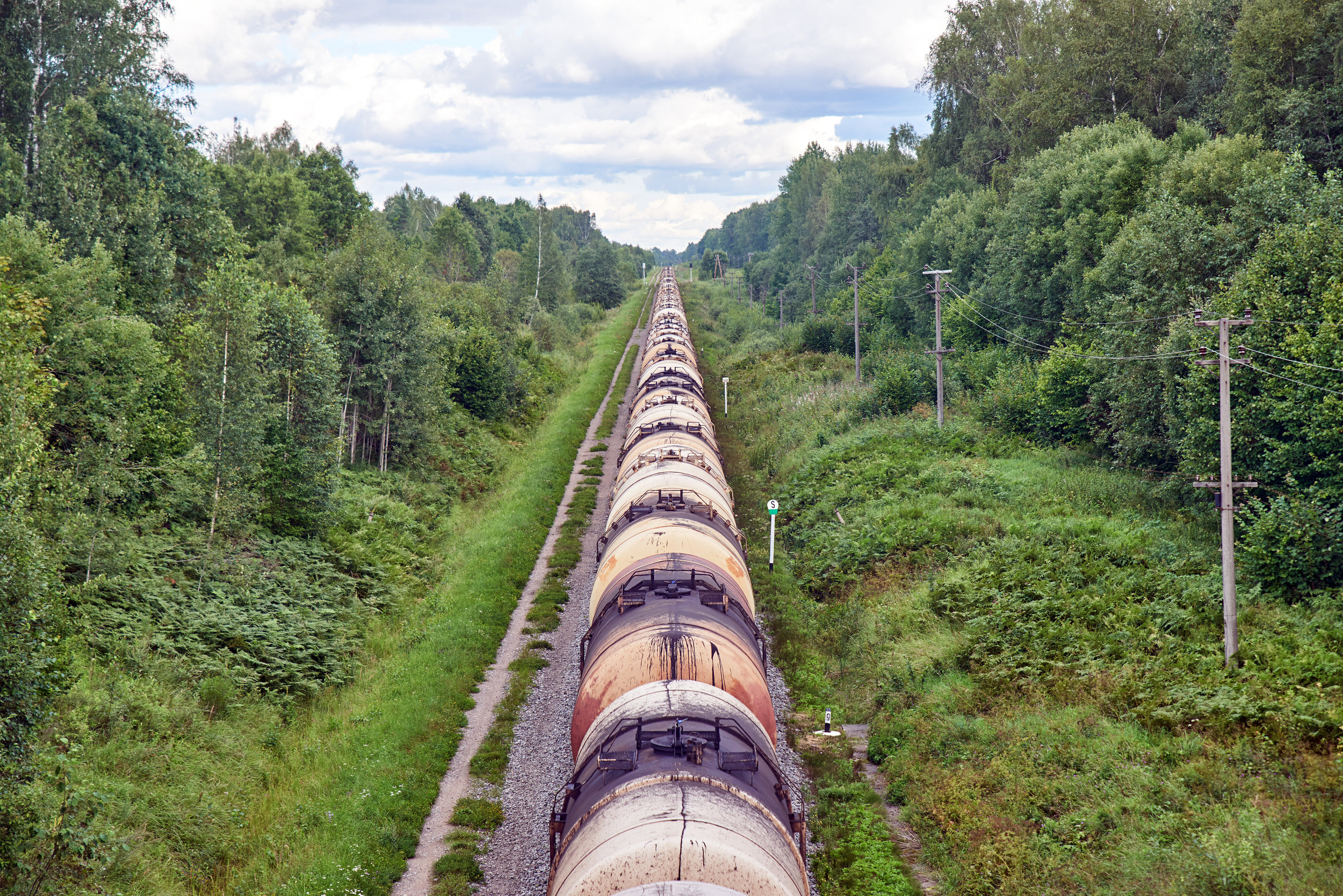 Set-of-train-tanks-with-oil-and-fuel-transport-by-rail---countryside-view-682538860_3866x2580.jpeg
