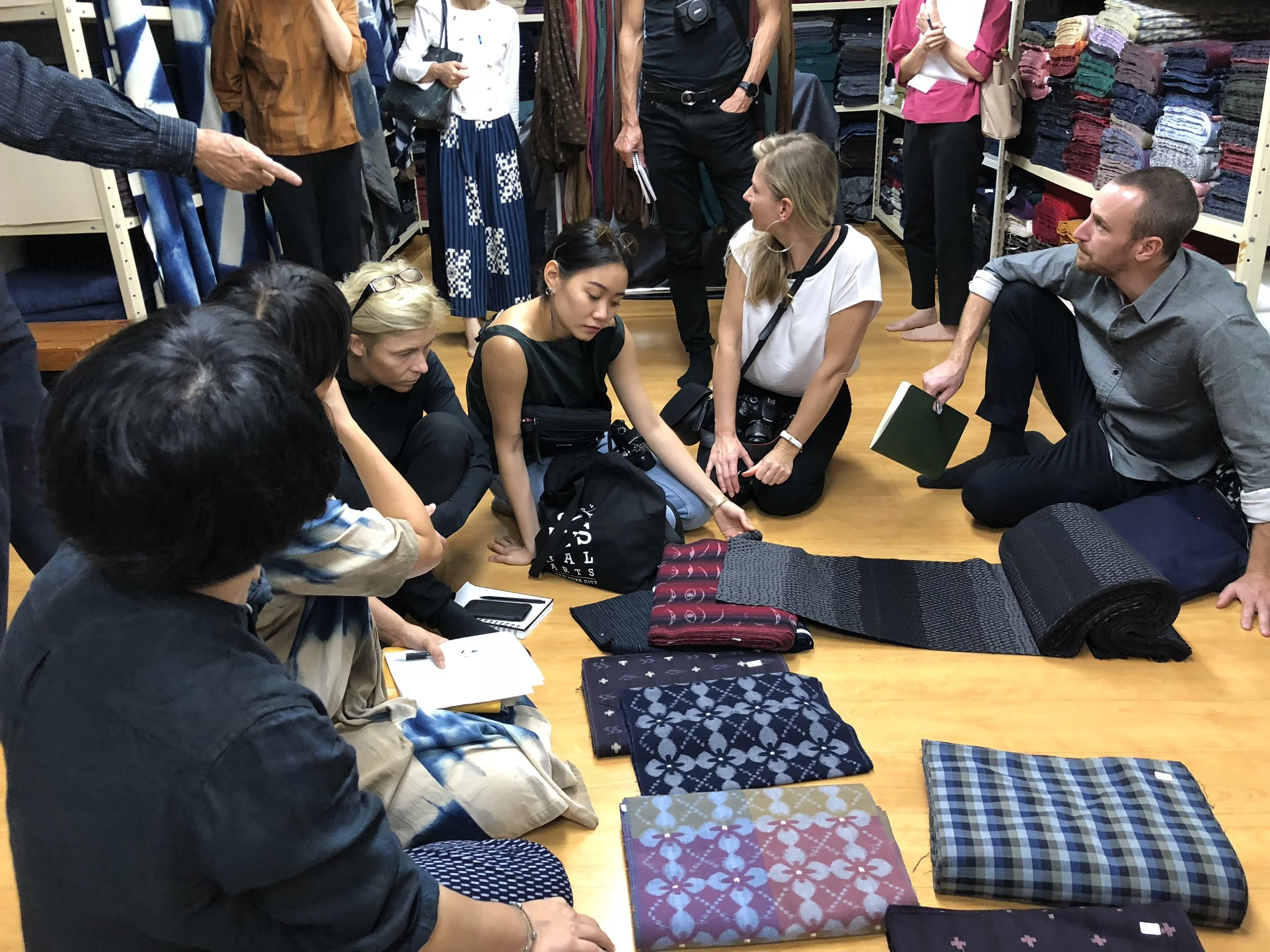  Designers touch and examine the ikat fabrics 