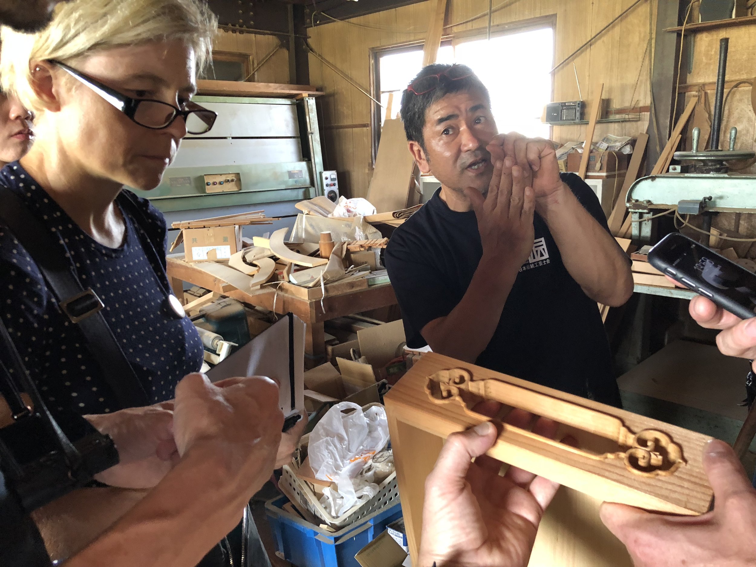  A craft person using hands to show his technique to a designer 