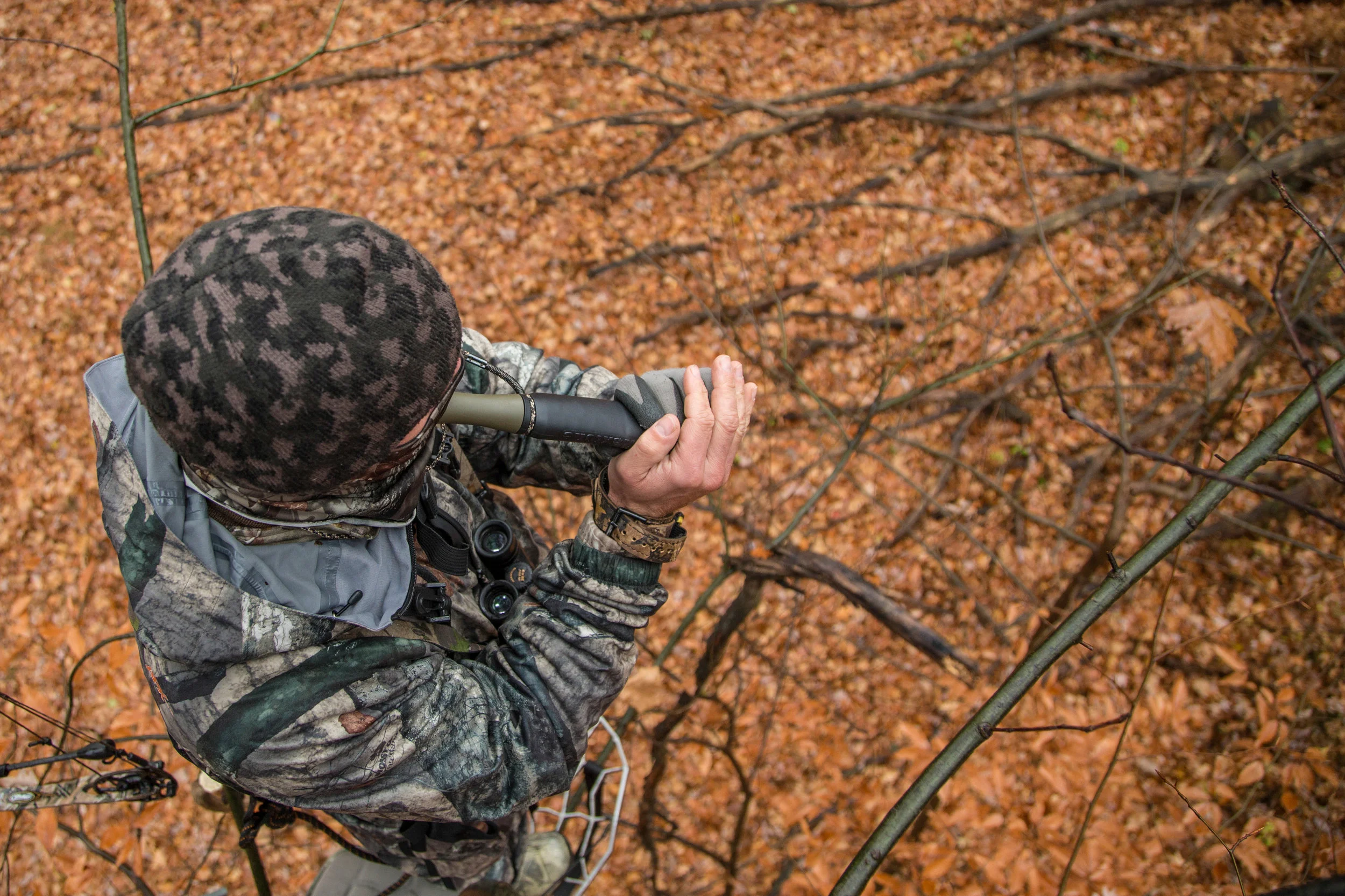 deer-hunter-using-grunt-call-in-treestand.jpg