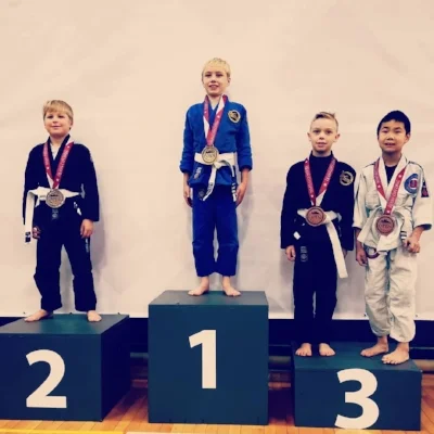 Roque Spaan-Murray on the podium after winning Gold in the Boys Featherweight Division. Phoenix Kivol (in black to the Roque’s right, won bronze.)