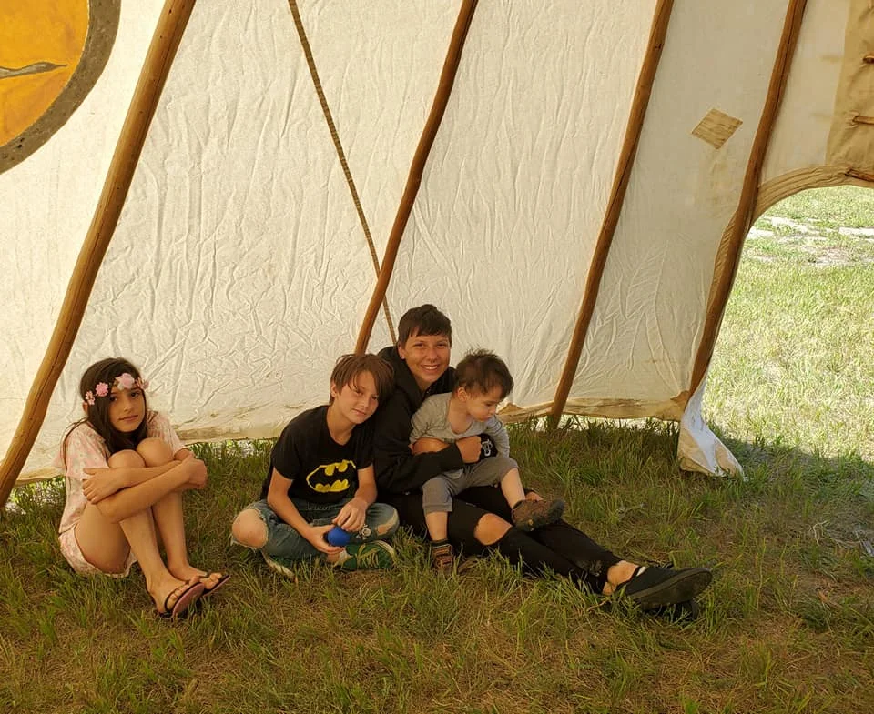 Some participants keep cool inside the teepee. Did you know because of air flow from the top to bottom of the teepee as well as the colouring made it 10 degrees cooler inside than outside? Photo by Kimberly Epp