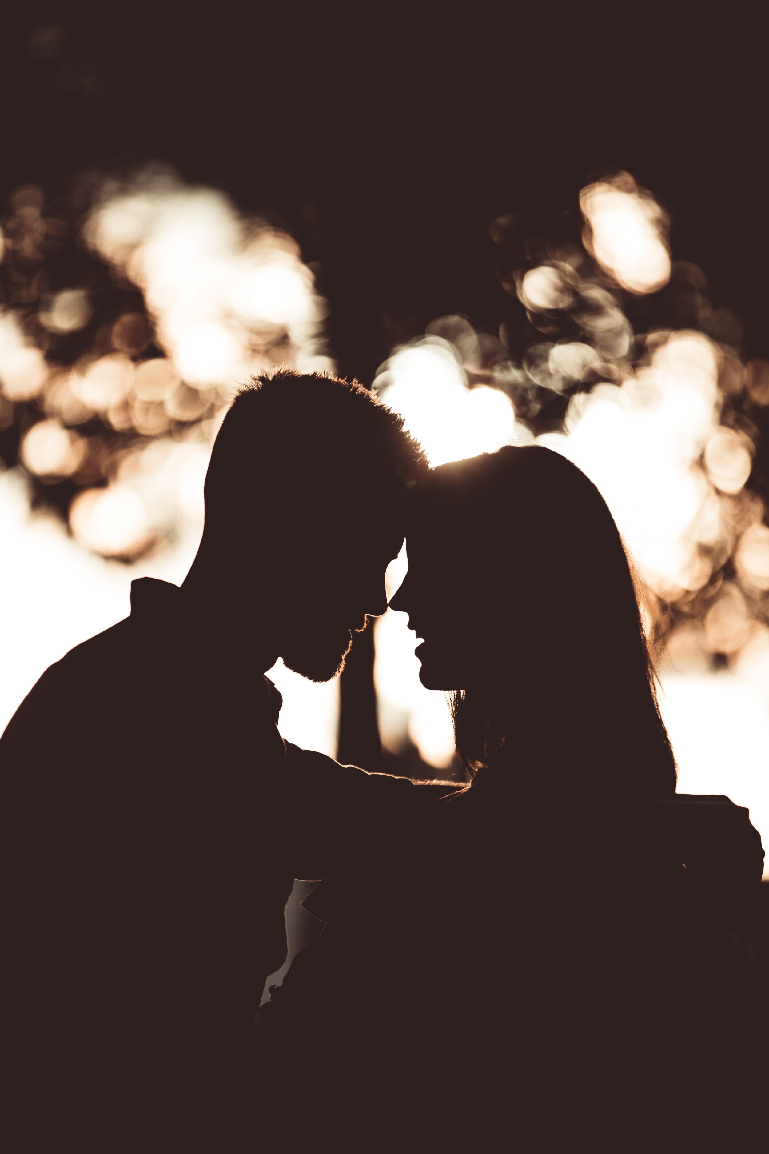 Couple in the twilight hugging and touching foreheads photo by Sean Stratton on Unsplash