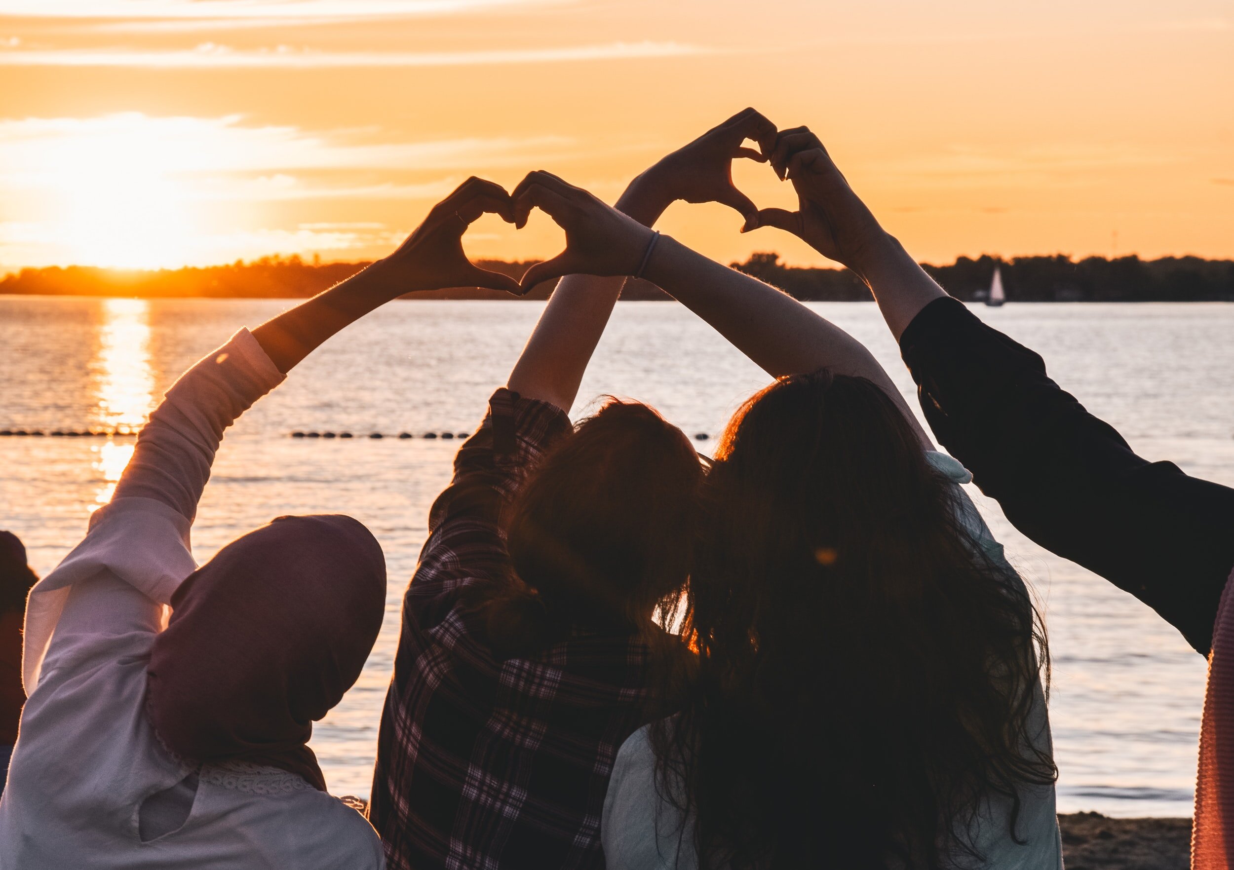 Photo by Noorulabdeen Ahmad on UnsplashA group of people put their hands together to form two hearts.