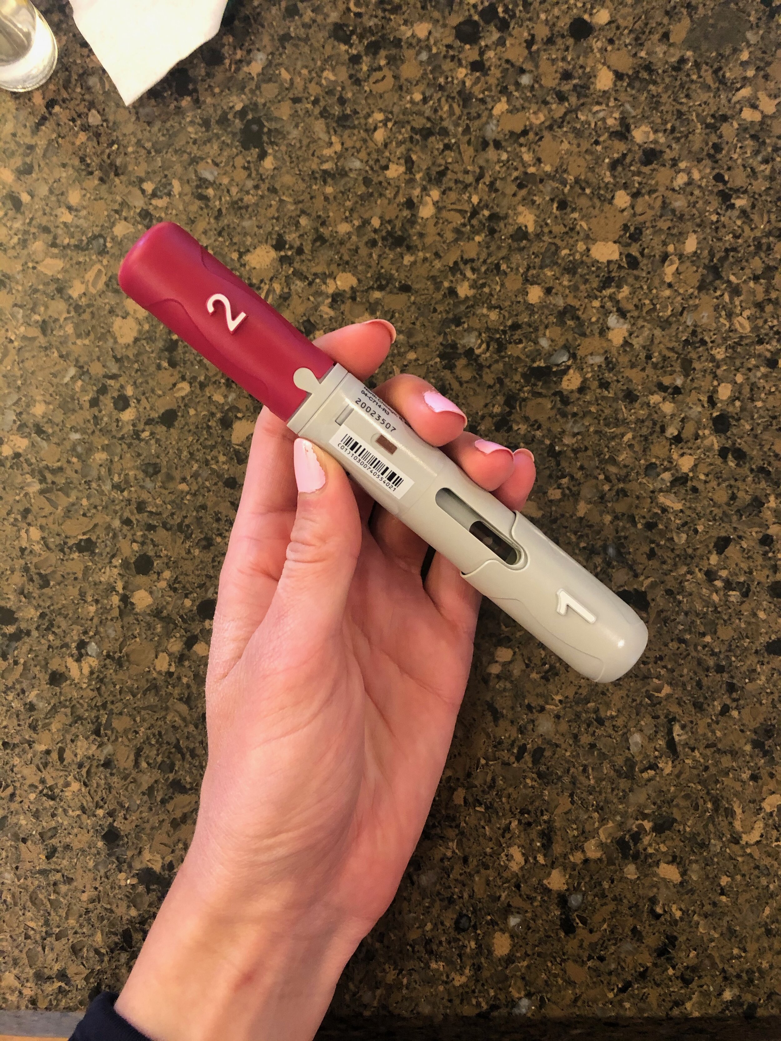 Image of the author holding a Humira pen.