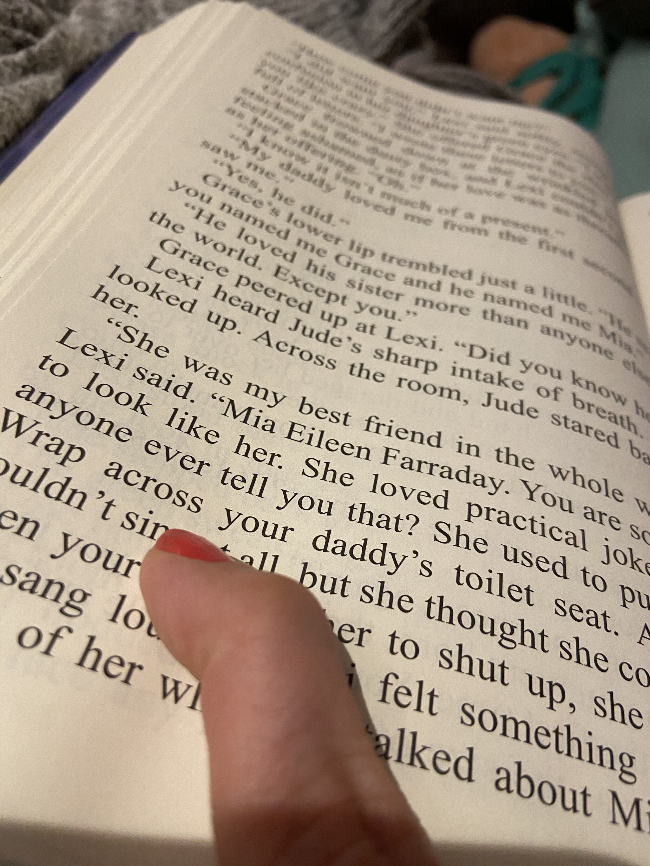 The author points to a section of a Kristen Hannah book that cracked her up. The text she is pointing to says, “She used to tape saran wrap across your daddy’s toilet.”