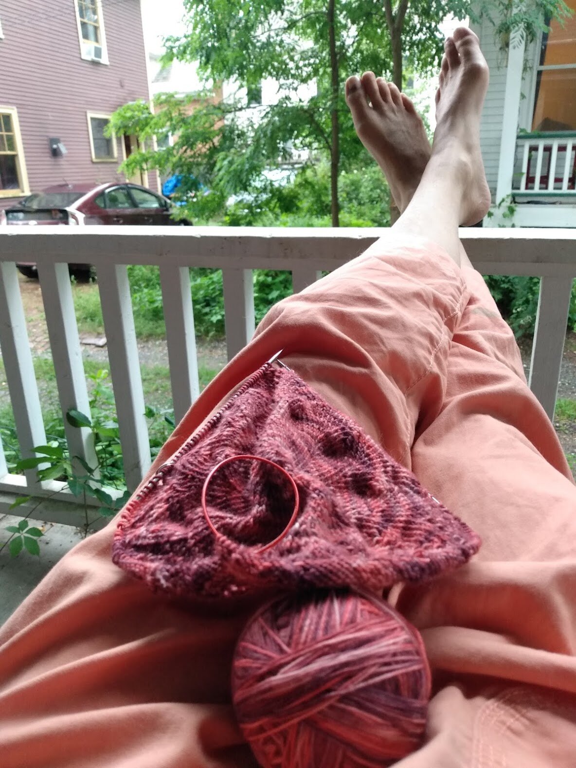 An image of a women’s lap (the blog author’s) and legs with knitting- part of my daily practice of self-care.