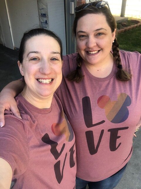 Image of Kayla with her wife, Elizabeth wearing pink t-shirts that say “love.”