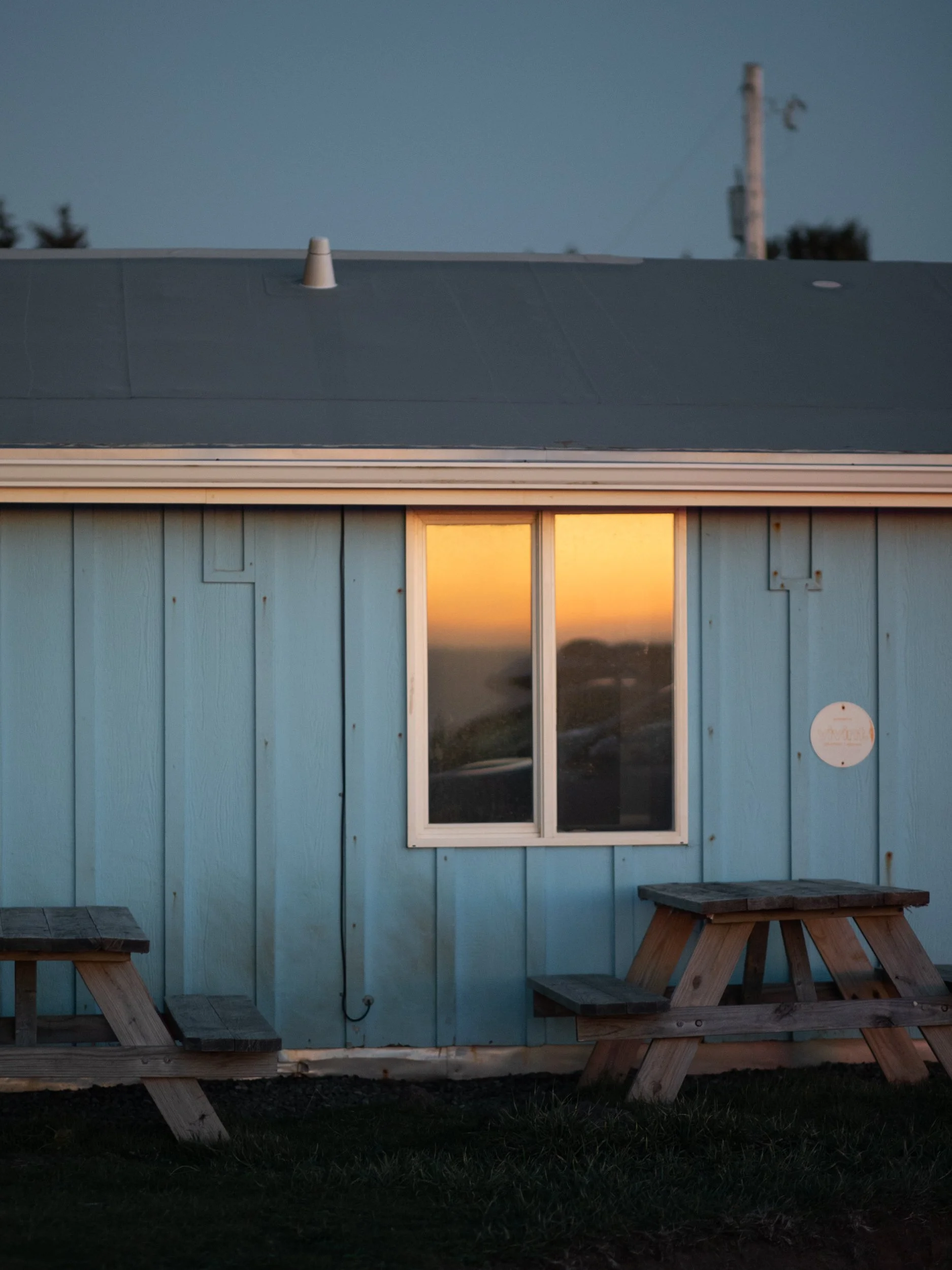 Sunset reflected in the window of blue coastal building