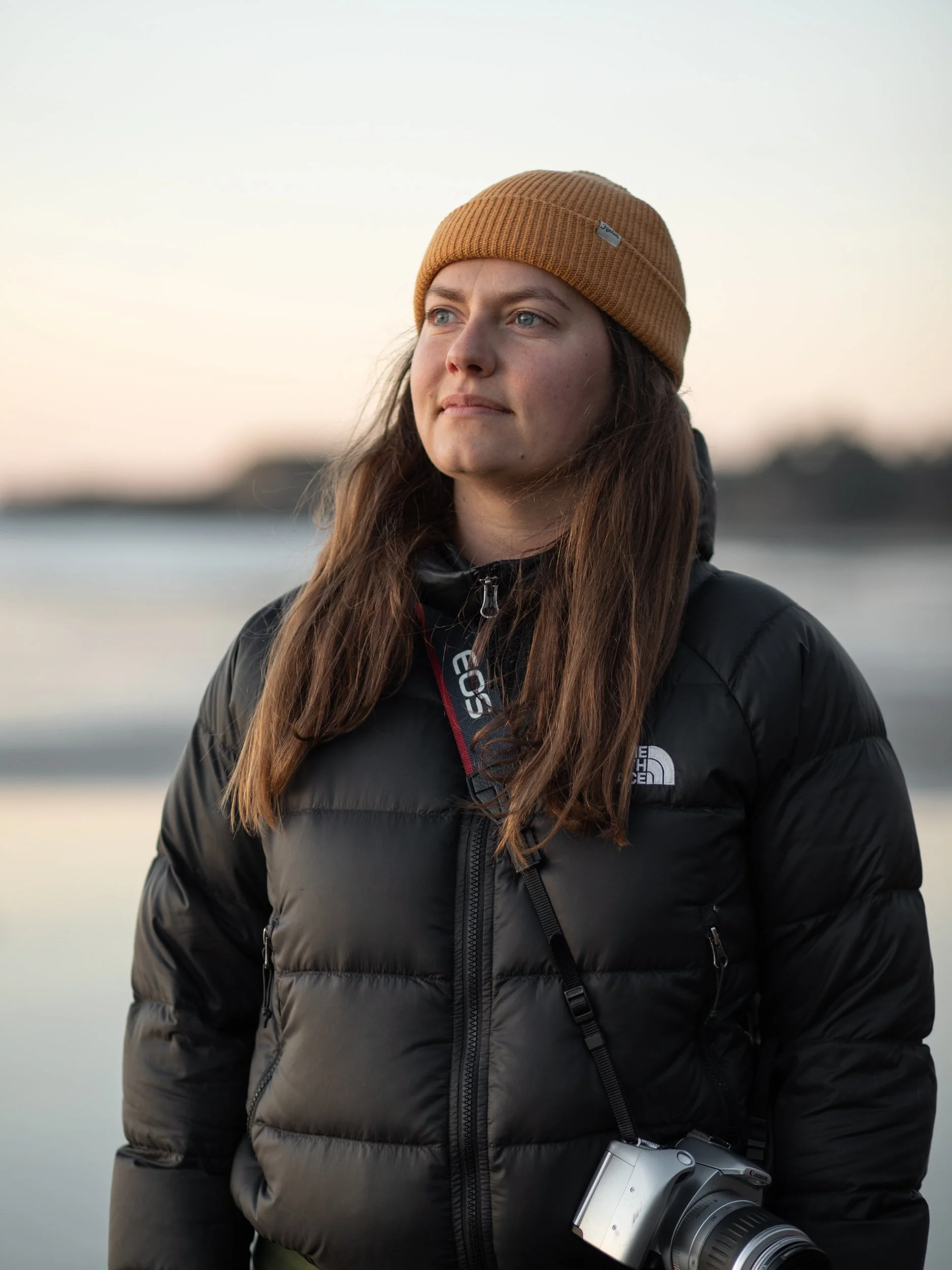 female with camera enjoying sunset on Oregon Coast