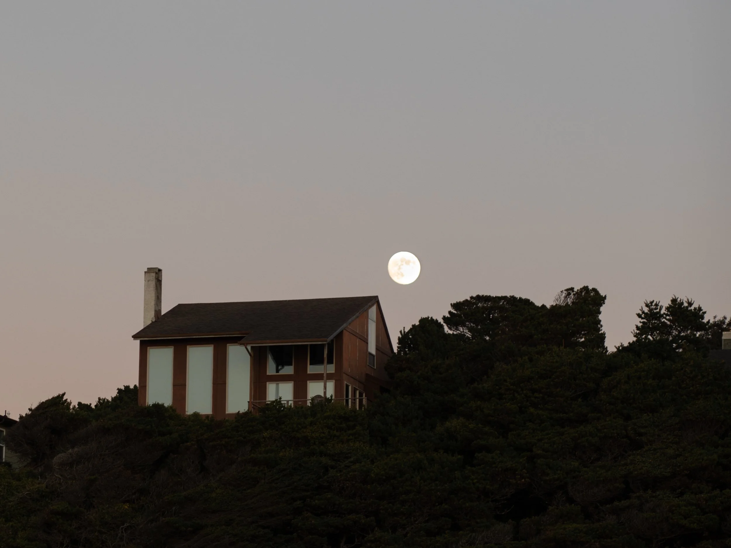 House on Oregon Coast with full moon in distance