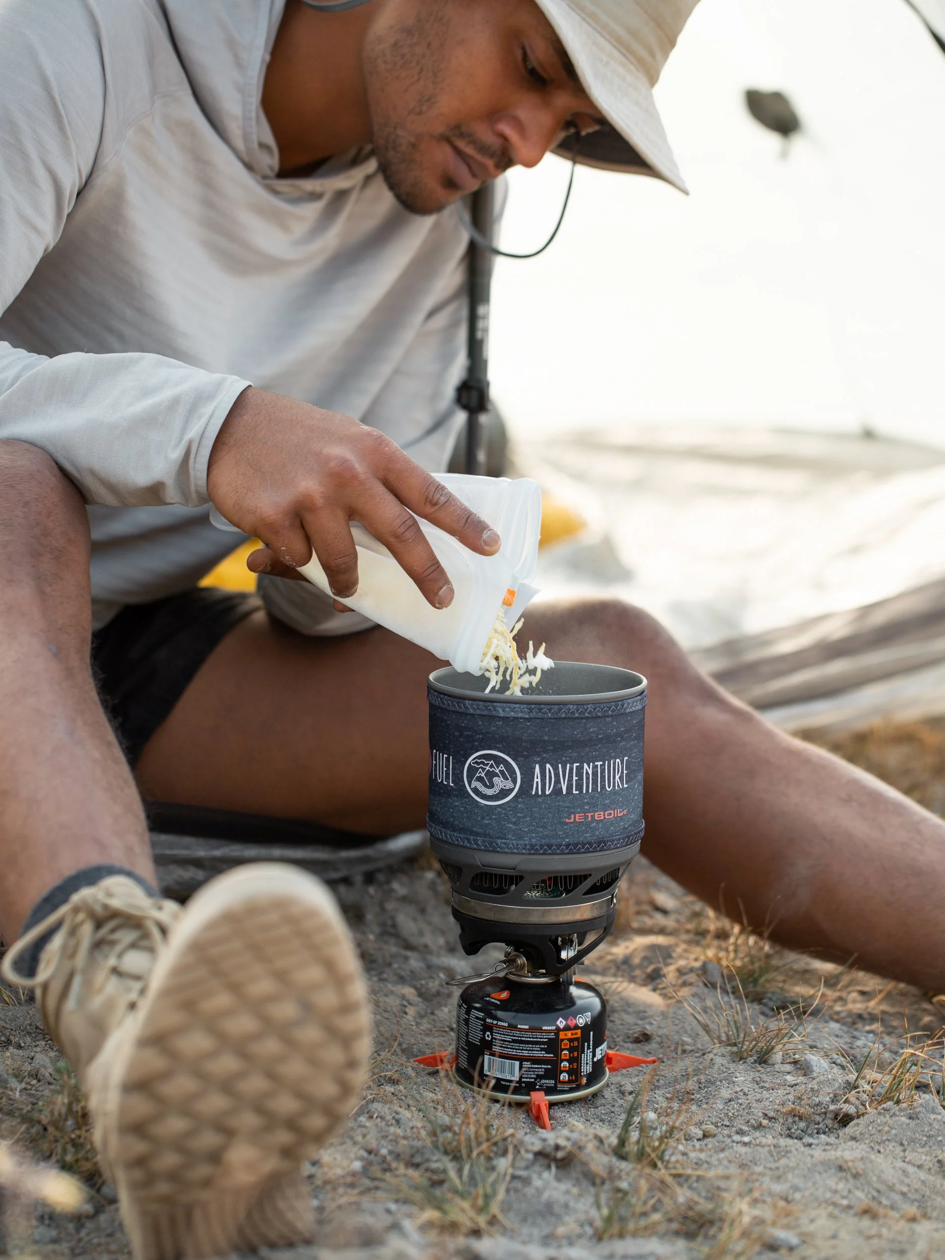 backpacker pours food into Jetboil Stove for dinner