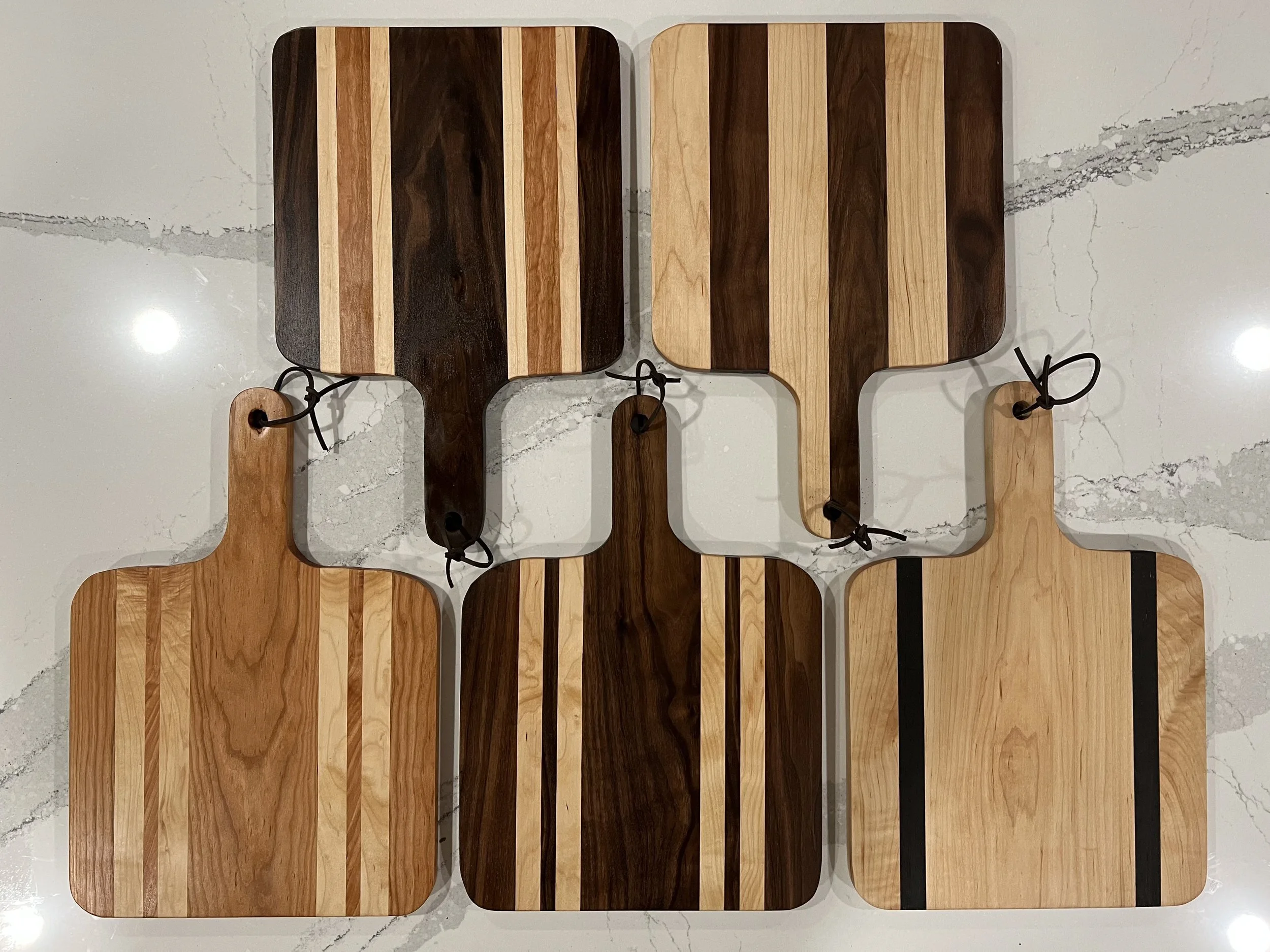 Charcuterie Holiday Box contents featuring: Large Handle Board, Zoet Farm Honey, Cinnamon Roasted Almonds, and Jalapeno Raspberry Jelly