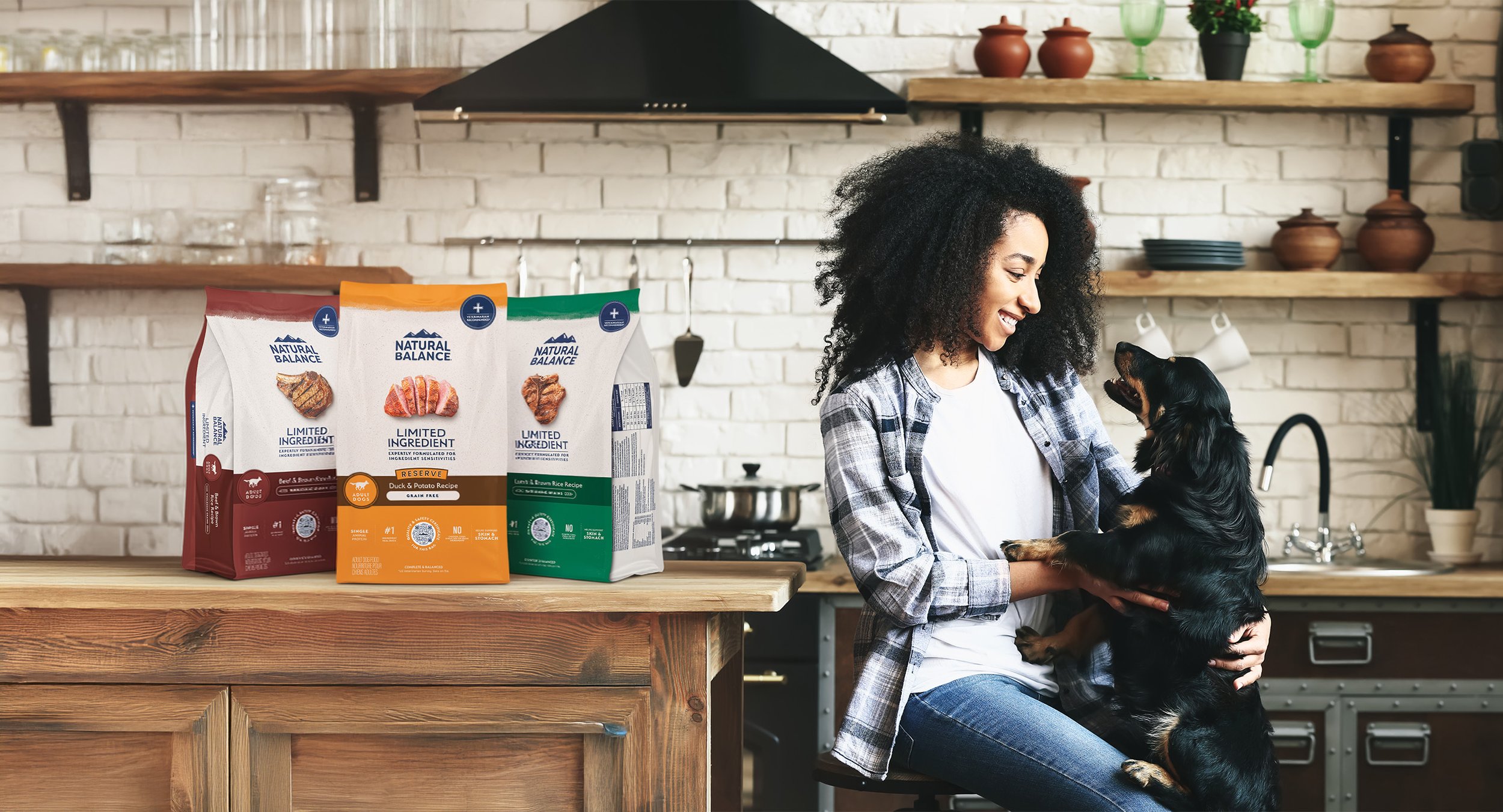 Woman in kitchen with dog by Natural Balance Limited Ingredient dry dog food