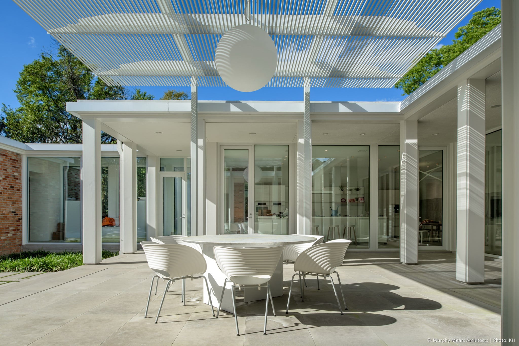 w-mid-century-modern-home-hugo-neuhaus-renovation-outdoor-dining-trellis-limestone2.jpg