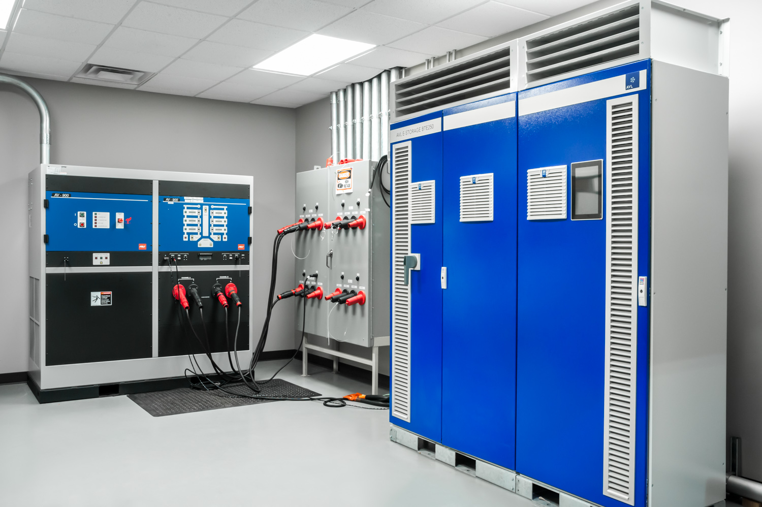 Electrical equipment in a utility room with control panels, circuit breakers, and cooling units.