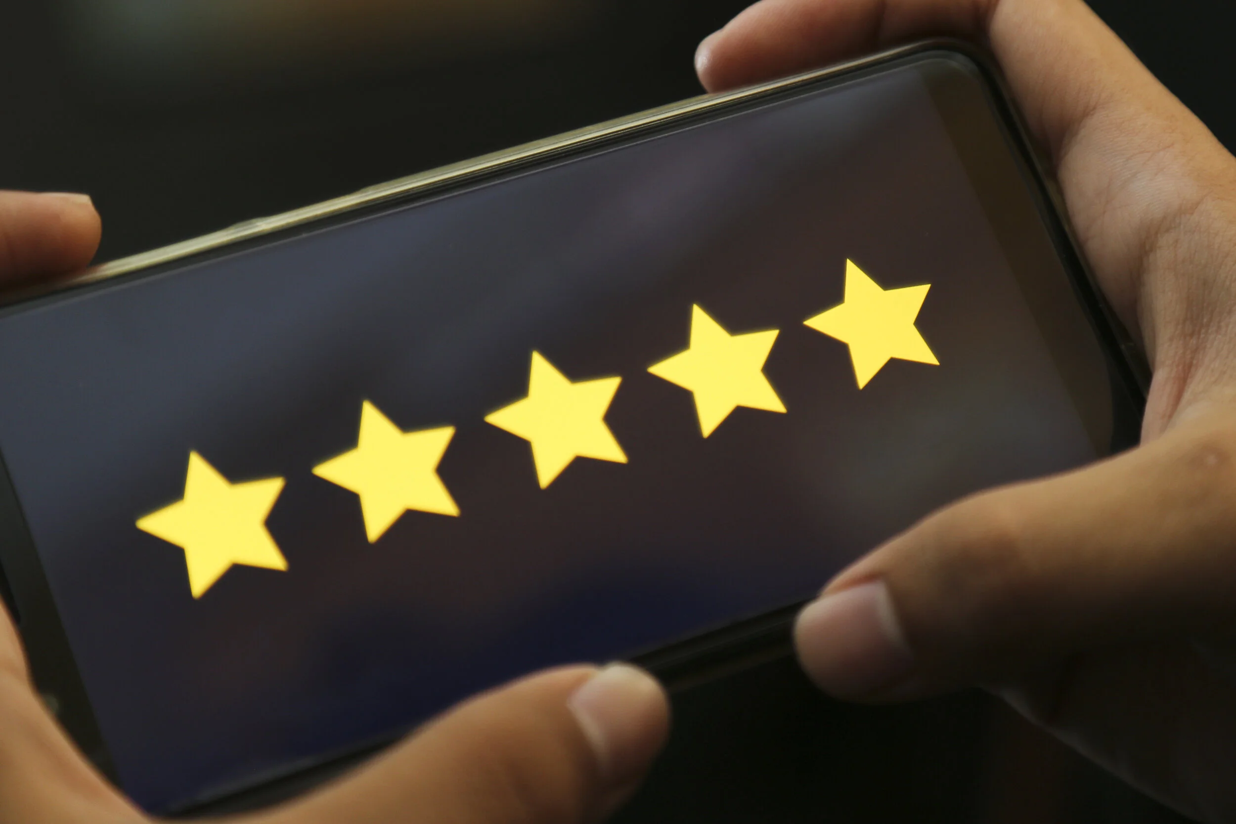 attractive hands giving five stars rating on a smart phone