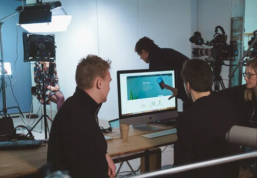 Bilde av et filmstudio med diverse utstyr og mennesker som jobber