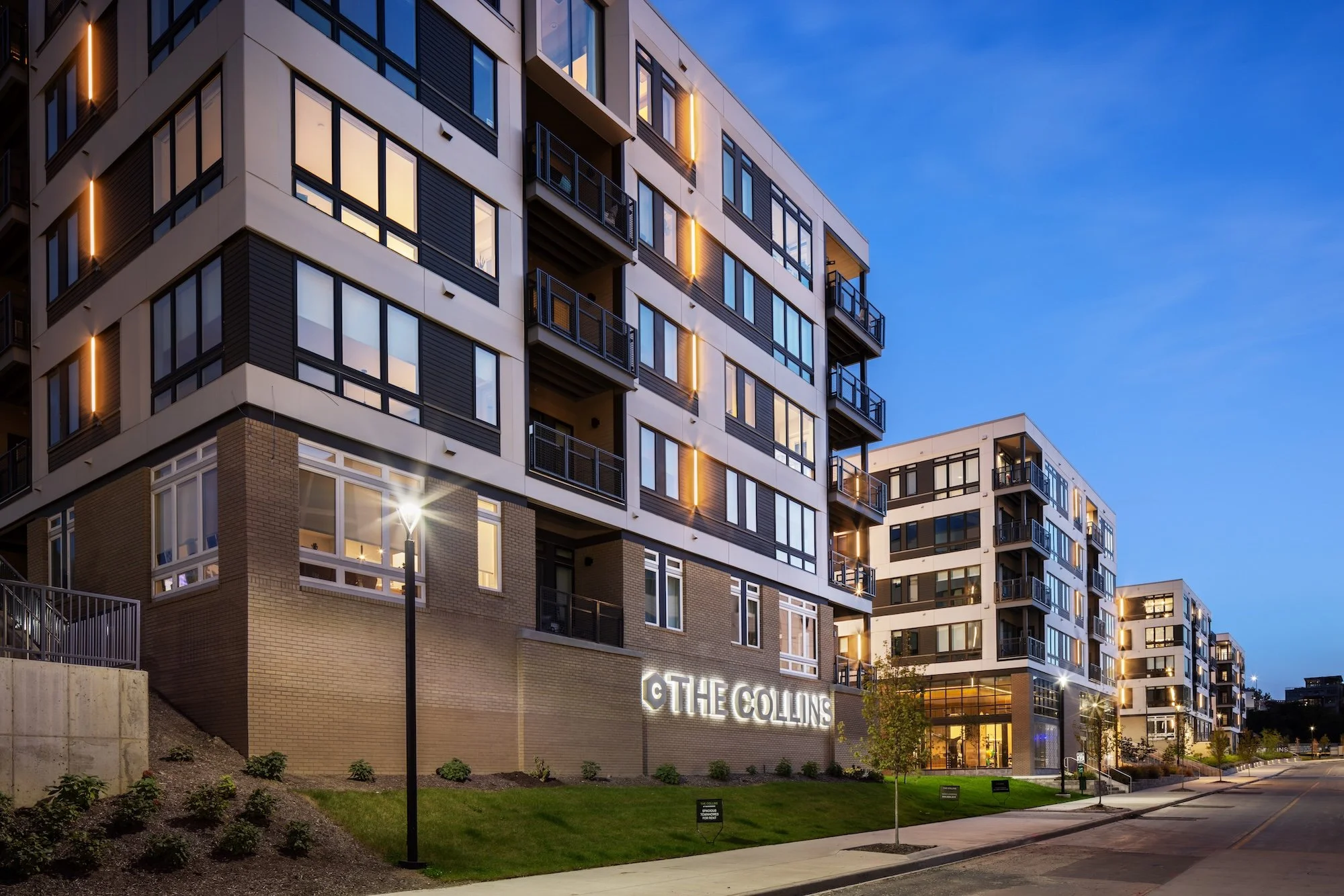 Evening view of The Collins residential community in Cleveland, highlighting the scale of the mixed-use development, contemporary architecture, and welcoming streetscape.