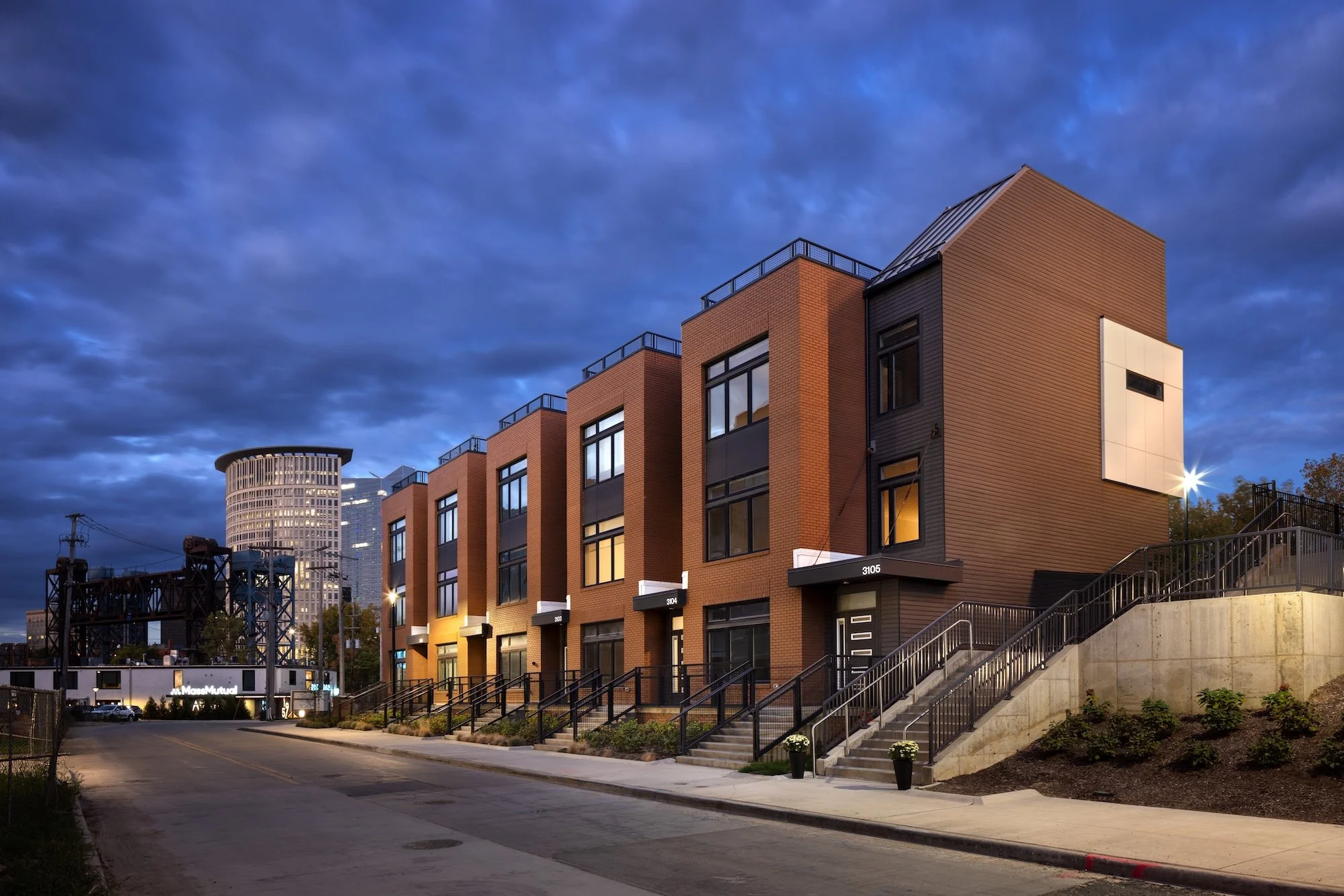 Contemporary brick townhomes at The Collins residential community in Cleveland, highlighting pedestrian-oriented streetscape, rooftop terraces, and modern multifamily design.